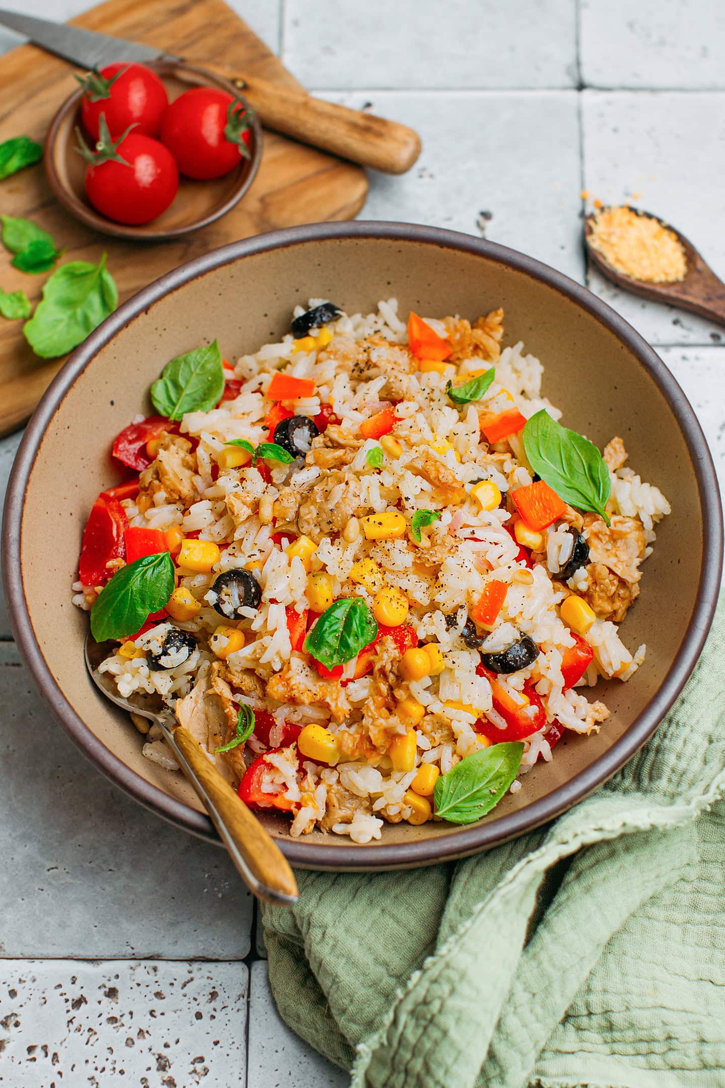 Rice salad with corn, basil, vegan tuna, and olives in a bowl.