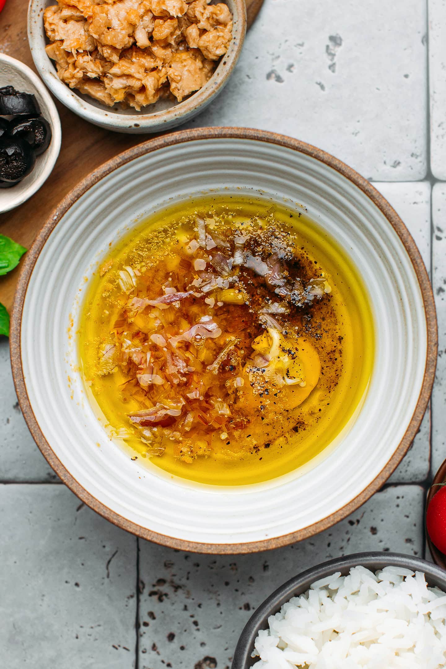 Olive oil, vinegar, mustard, and shallot in a bowl.