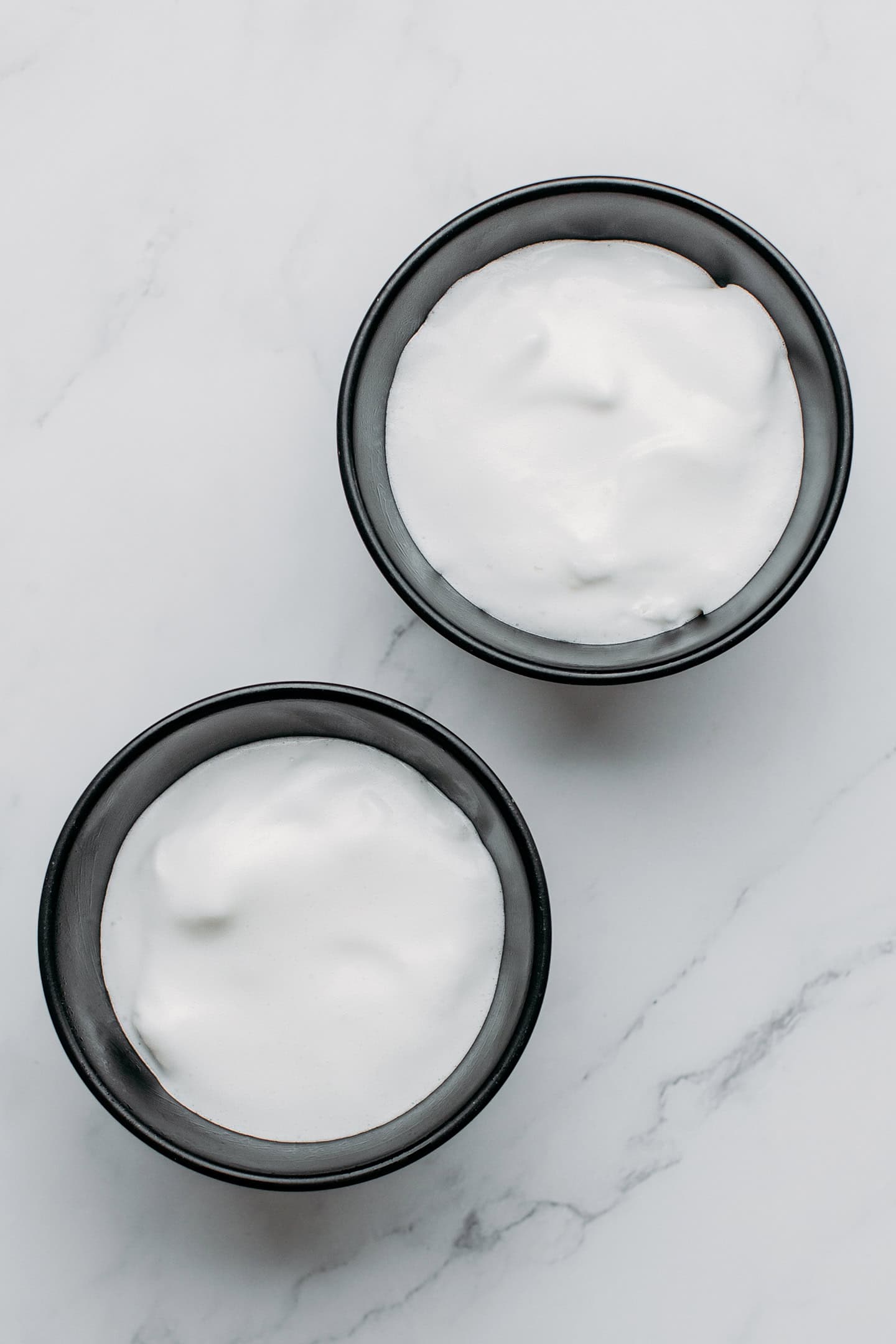 Aquafaba poured into two small bowls.