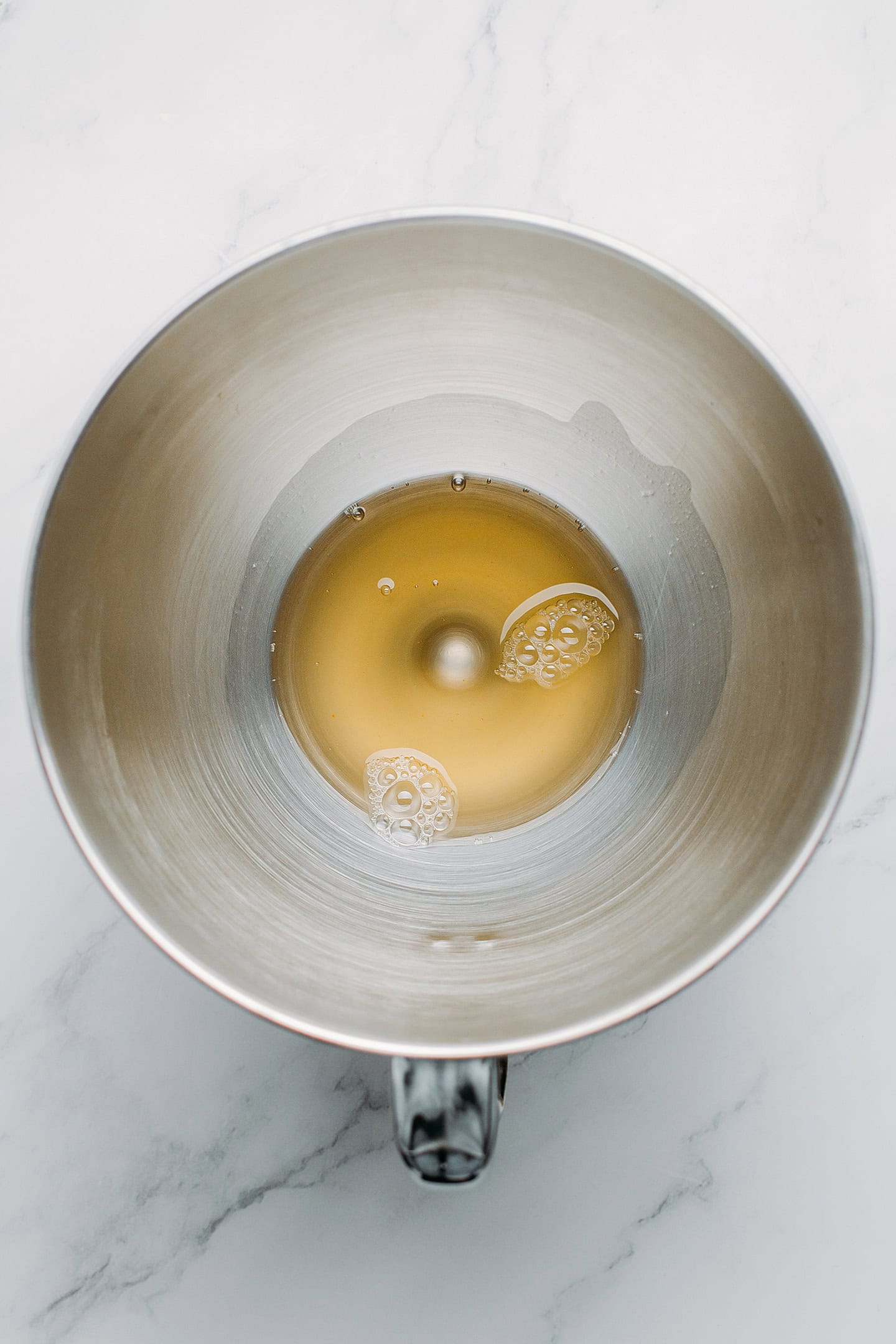 Aquafaba in the bowl of a stand mixer.