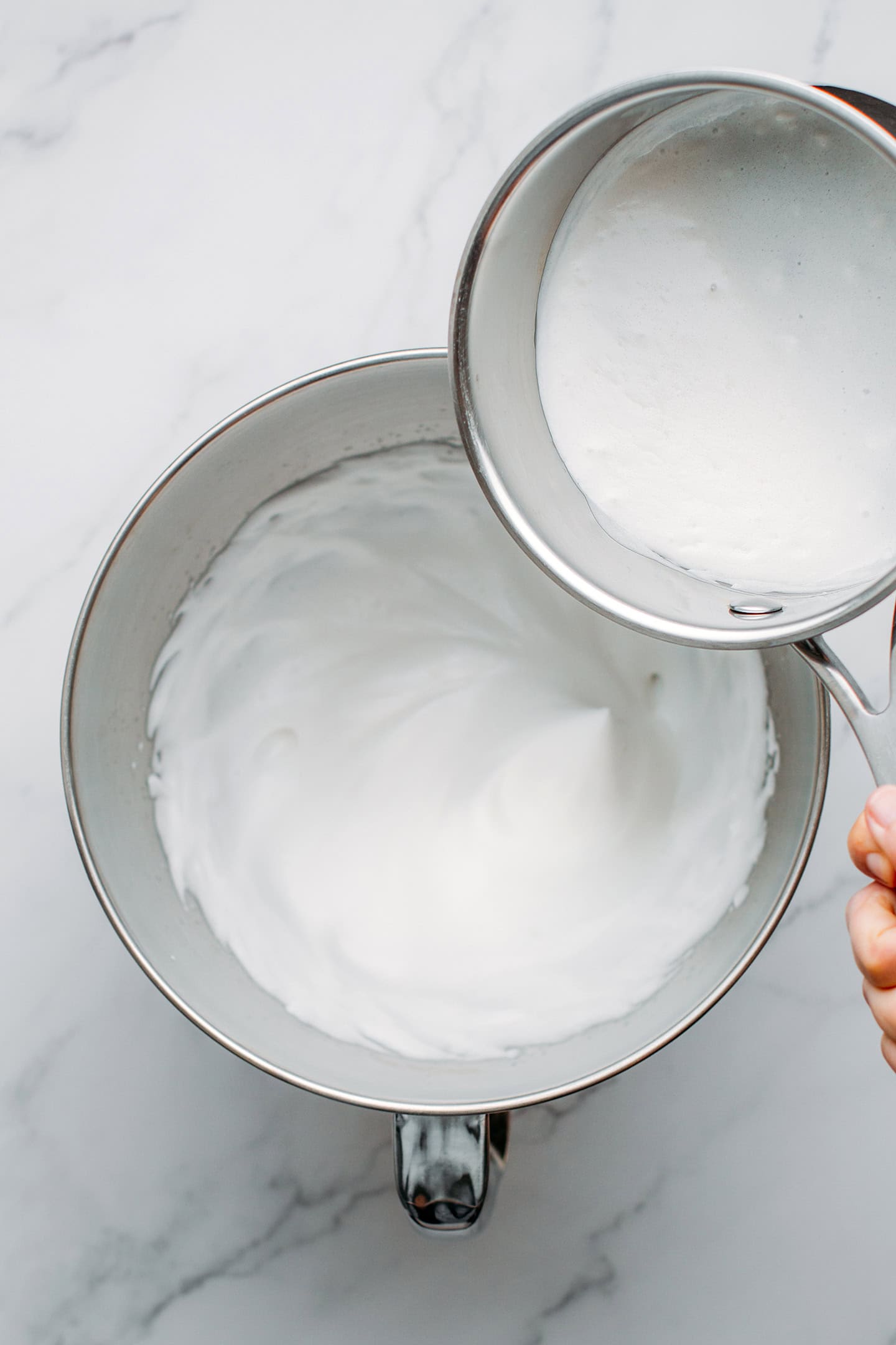 Pouring coconut cream into aquafaba.