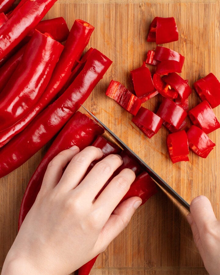 Chopping cayenne peppers into thick slices.