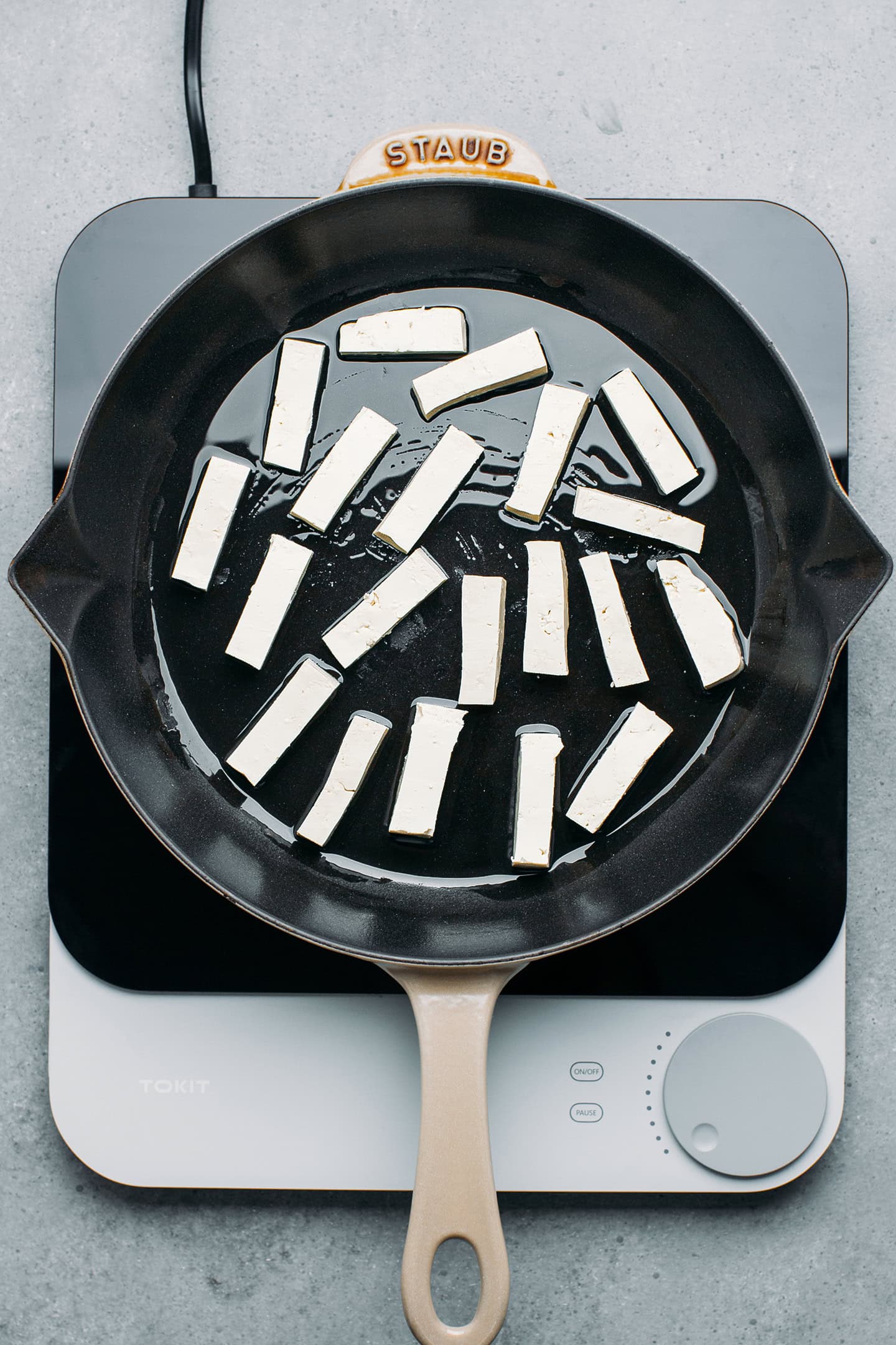 Tofu strips in a skillet.