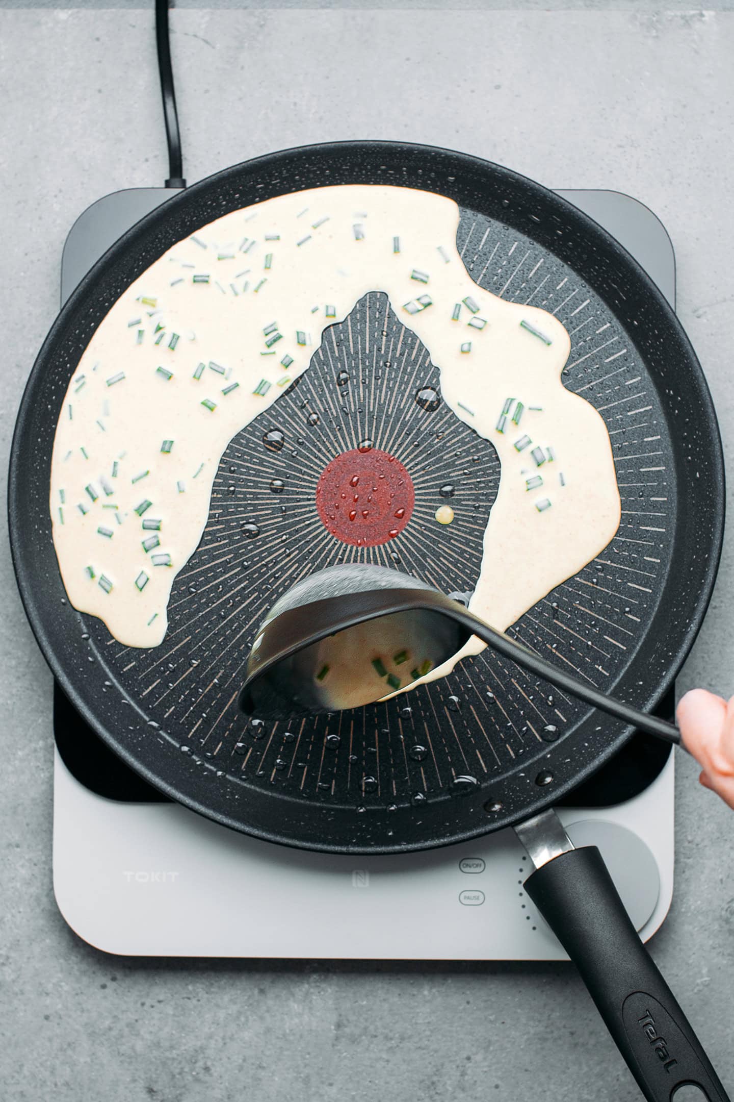 Pouring rice flour batter into a skillet.