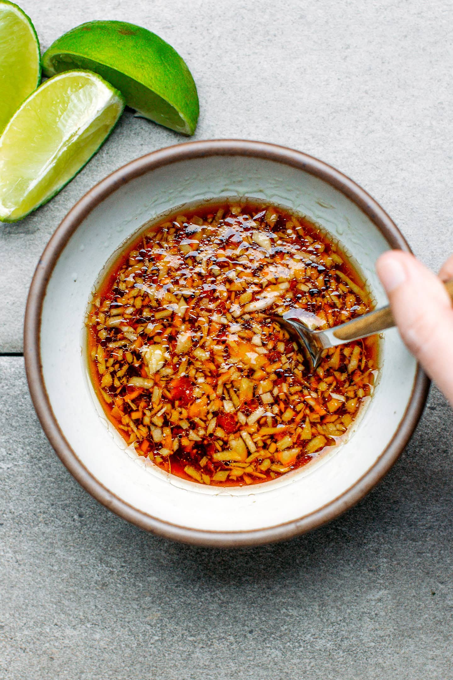 Stirring soy sauce dressing in a small bowl.