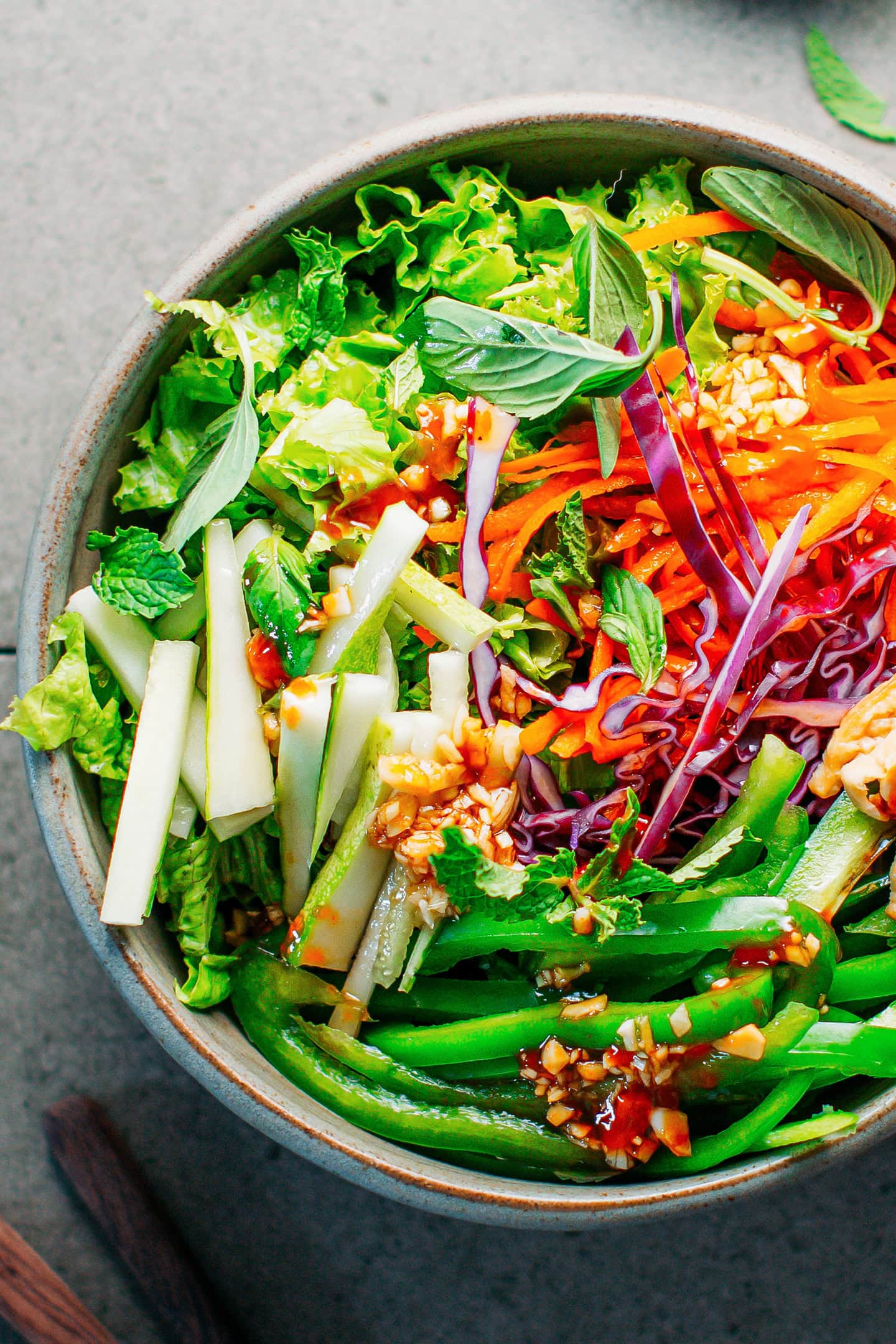 Close-up of a mint and basil salad with cucumber, red cabbage, and lettuce.