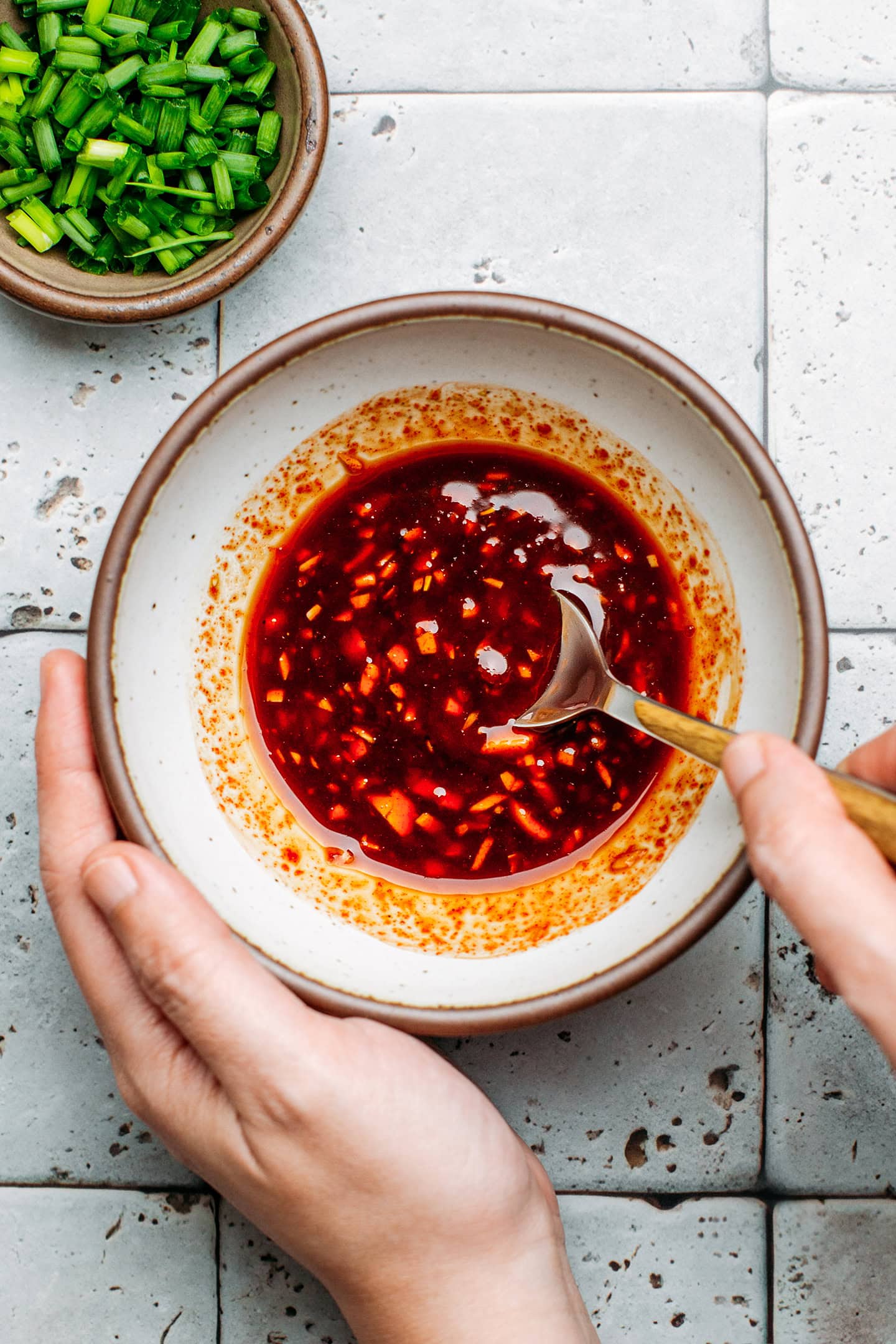 Stirring gochujang sauce in a small bowl.