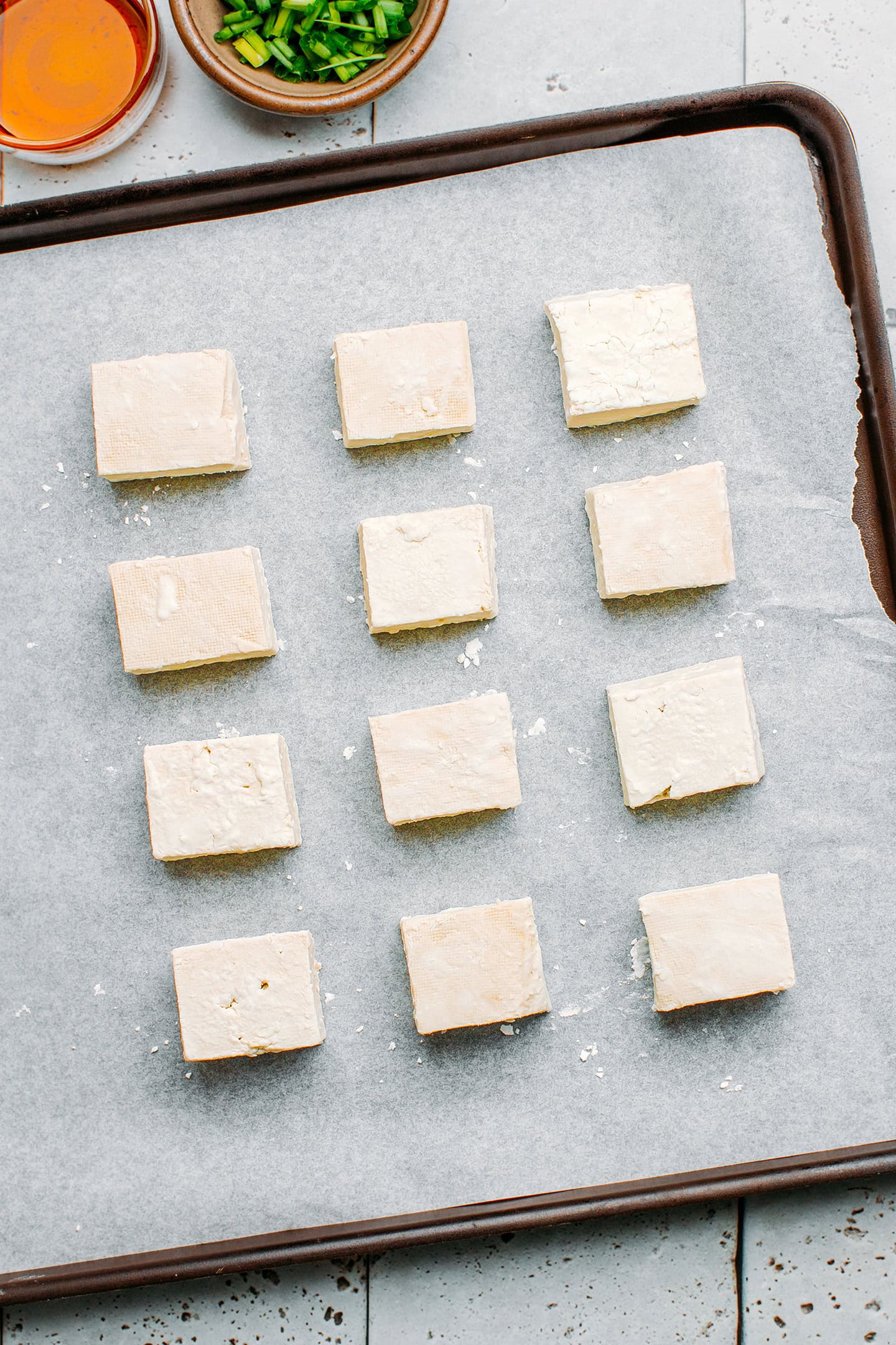 Diced tofu coated with cornstarch on a baking sheet.