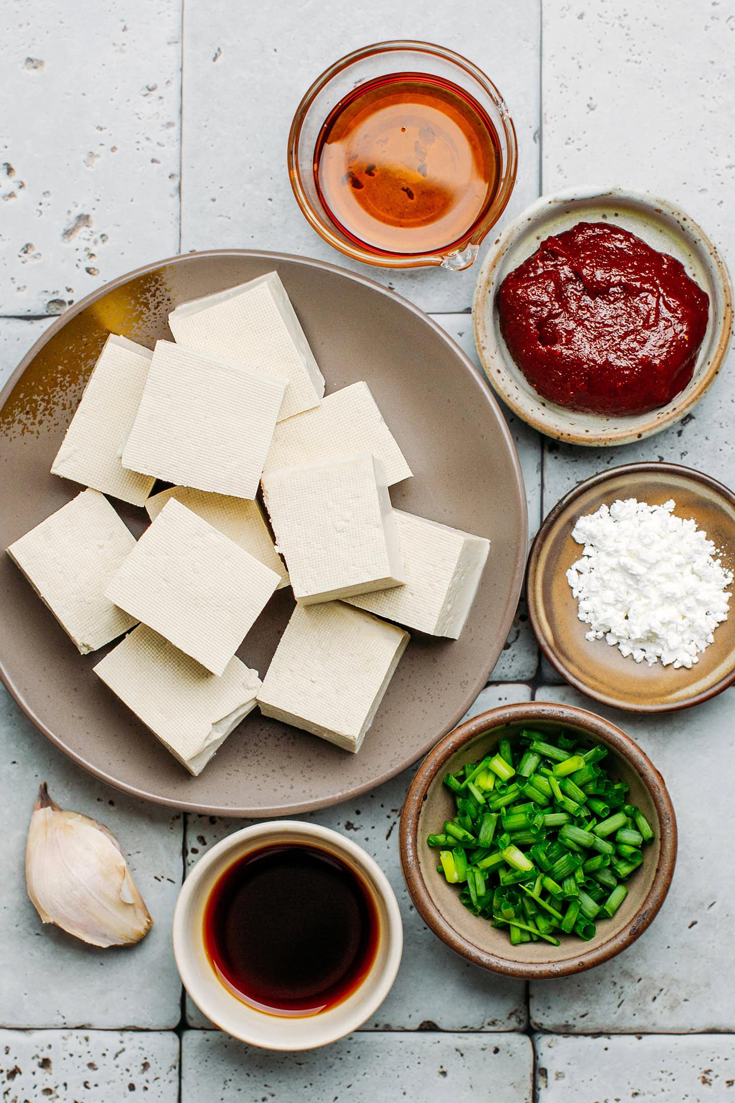 Ingredients like tofu, gochujang, garlic, soy sauce, and green onions.