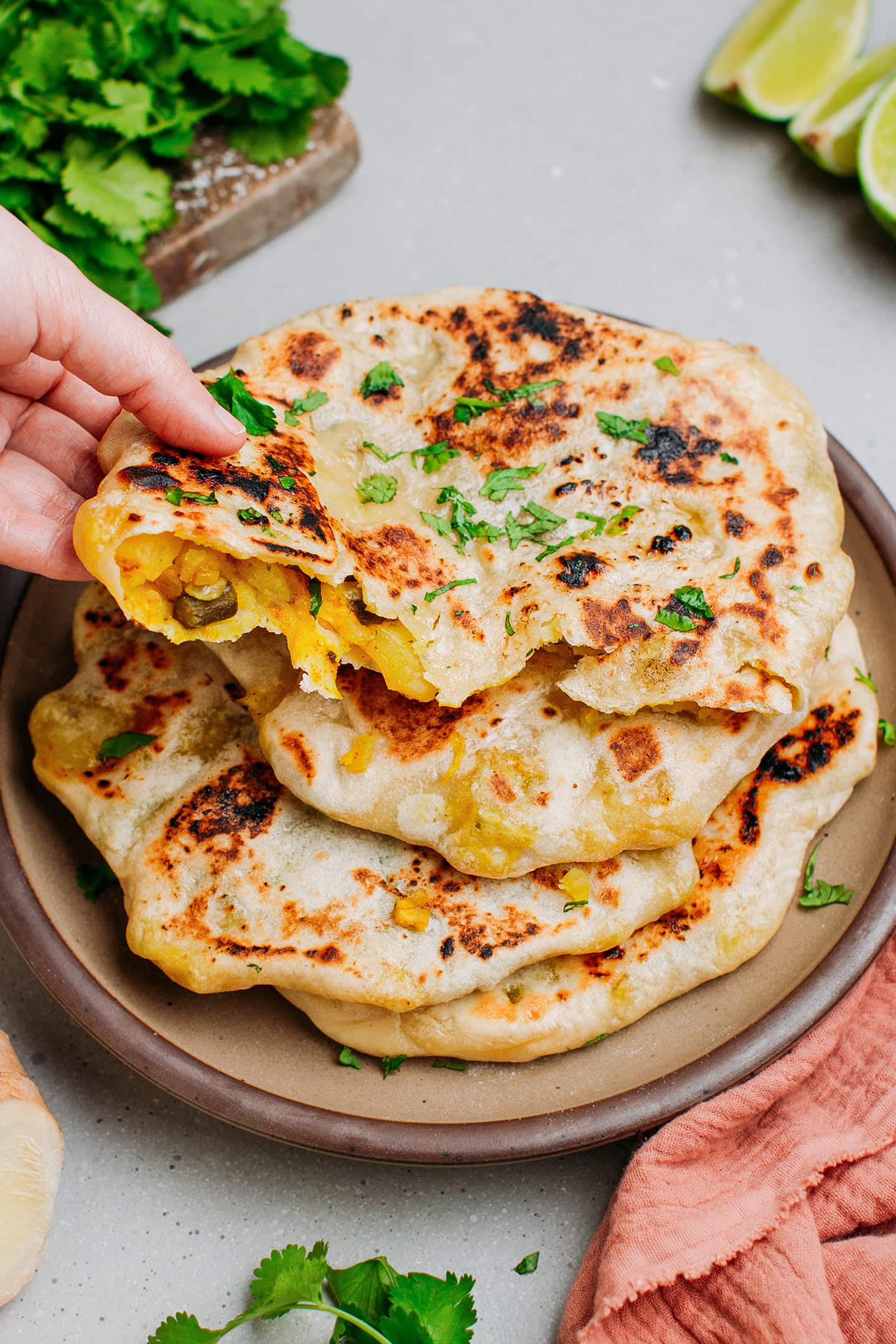 Holding a naan filled with potatoes and green beans.