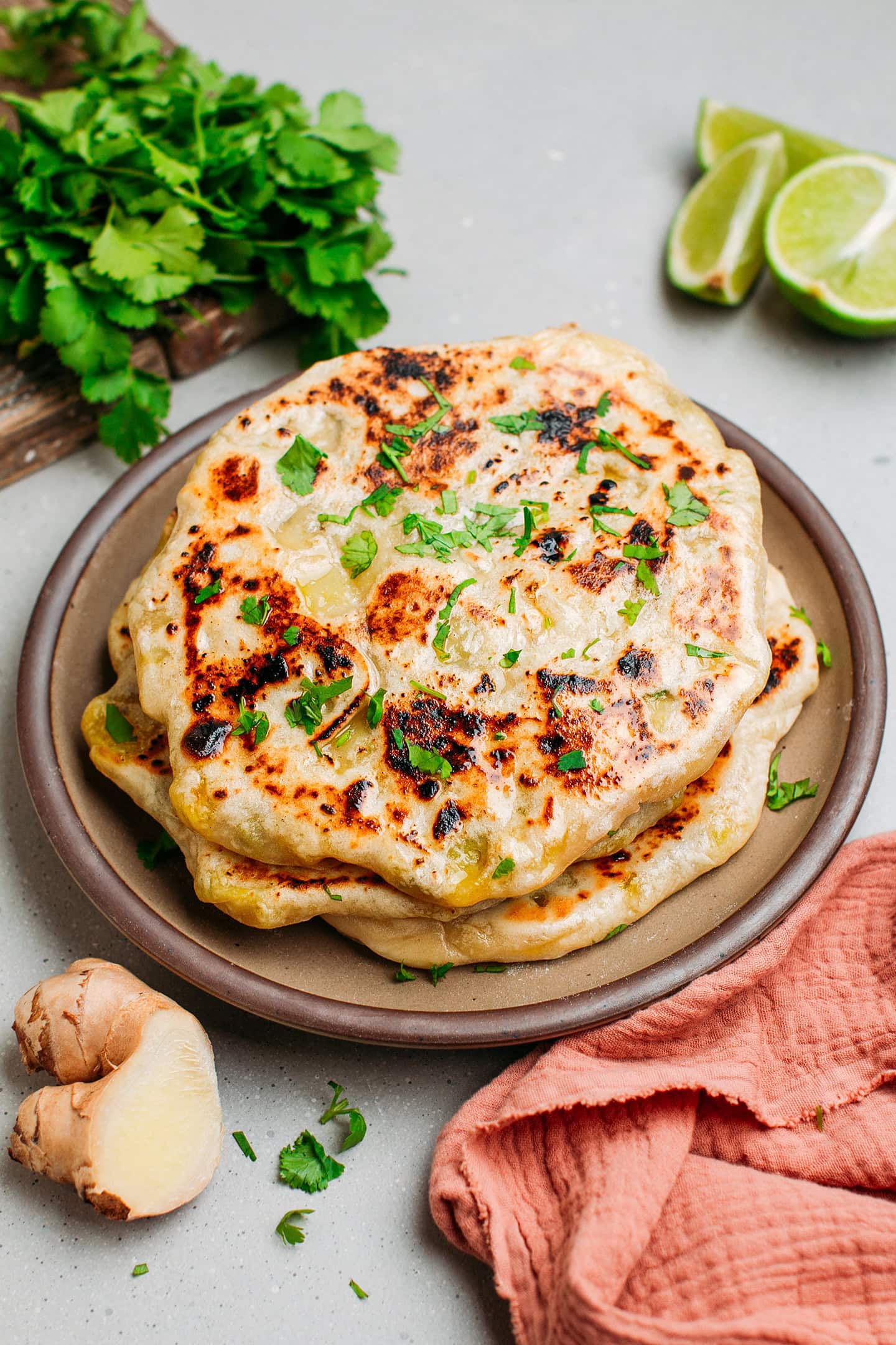 Stack of naans topped with cilantro on a plate.