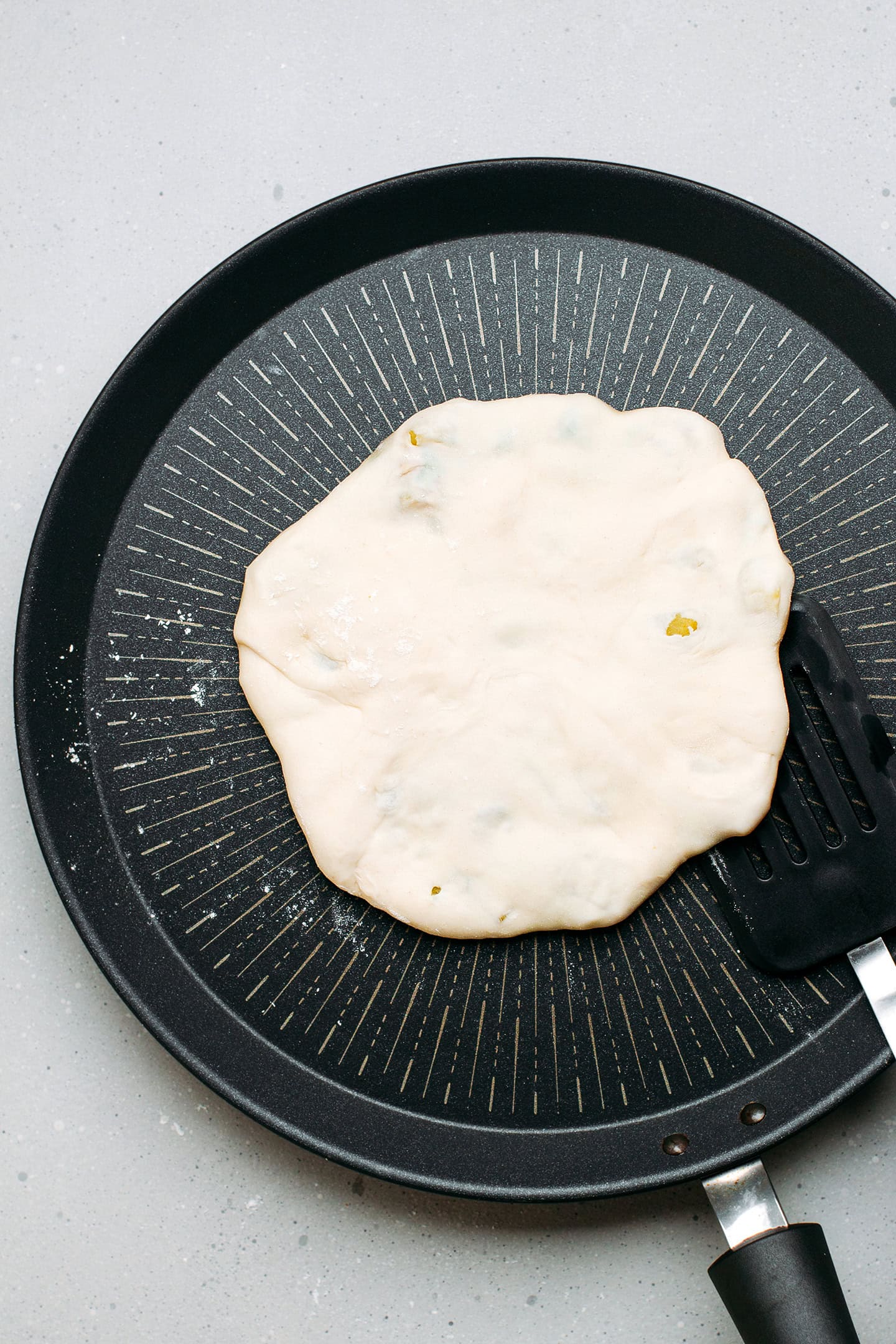 Flipping a naan on a non-stick skillet.