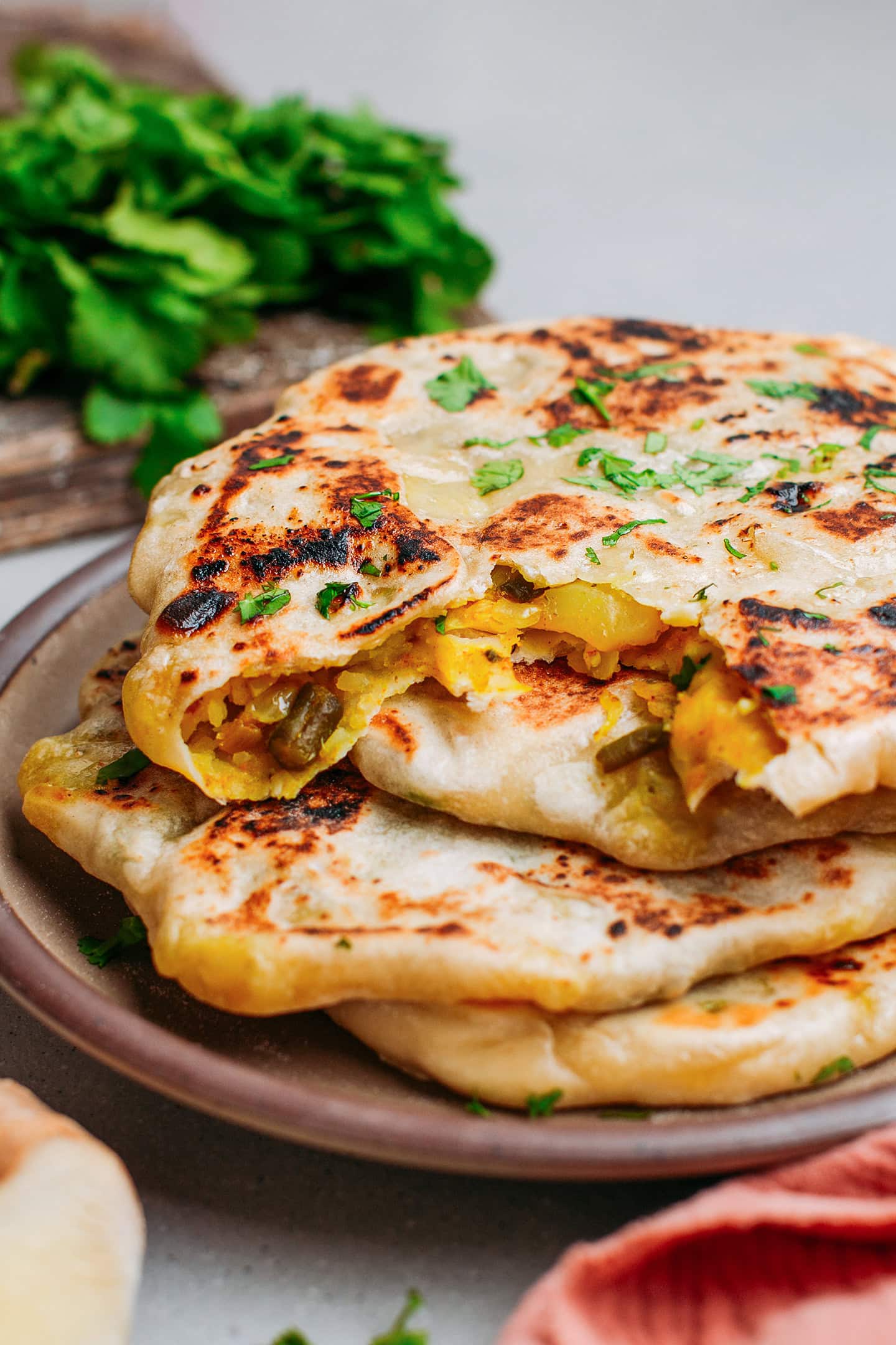 Close-up of a naan stuffed with potato and green bean.