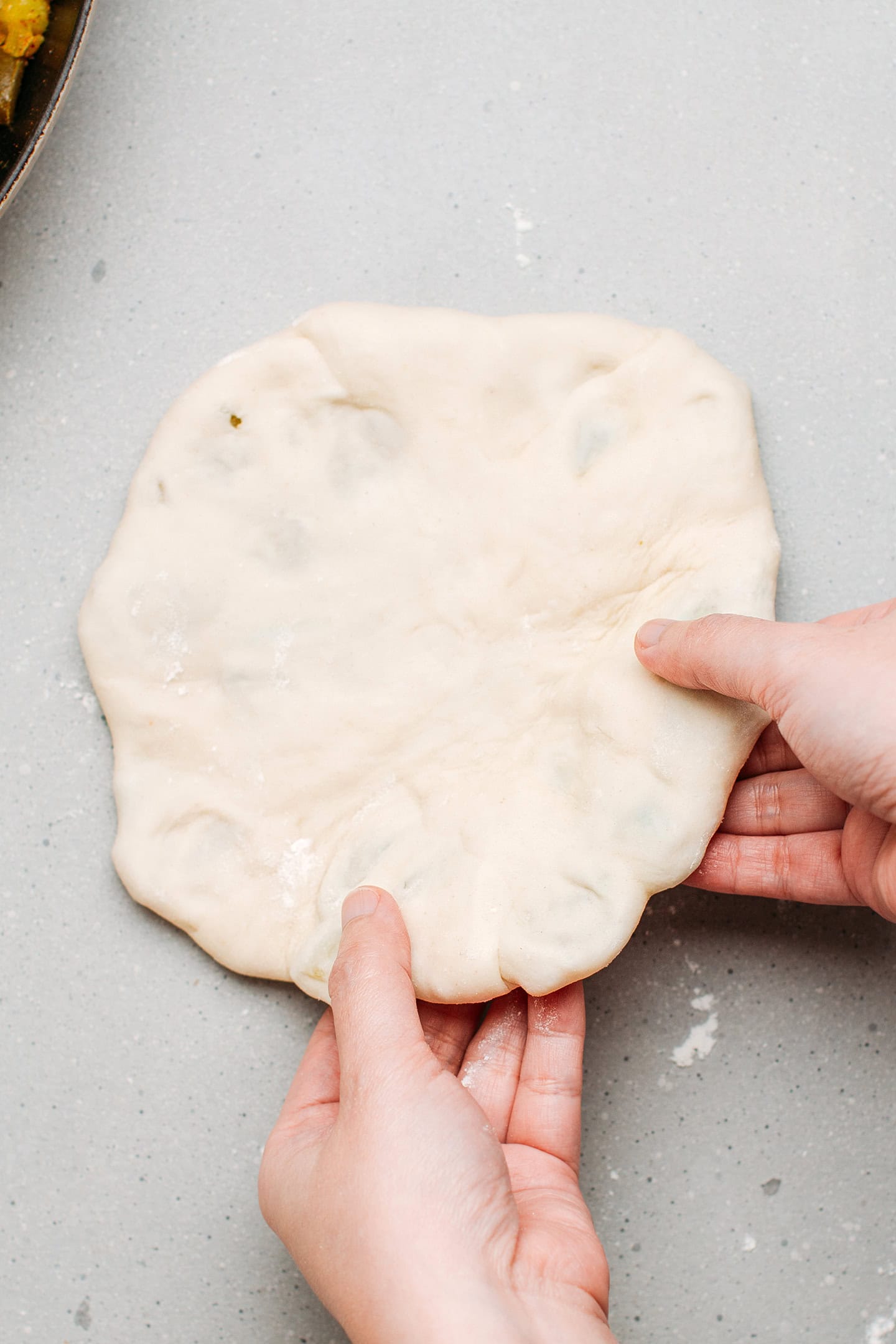 Holding a naan filled with potato and green beans.