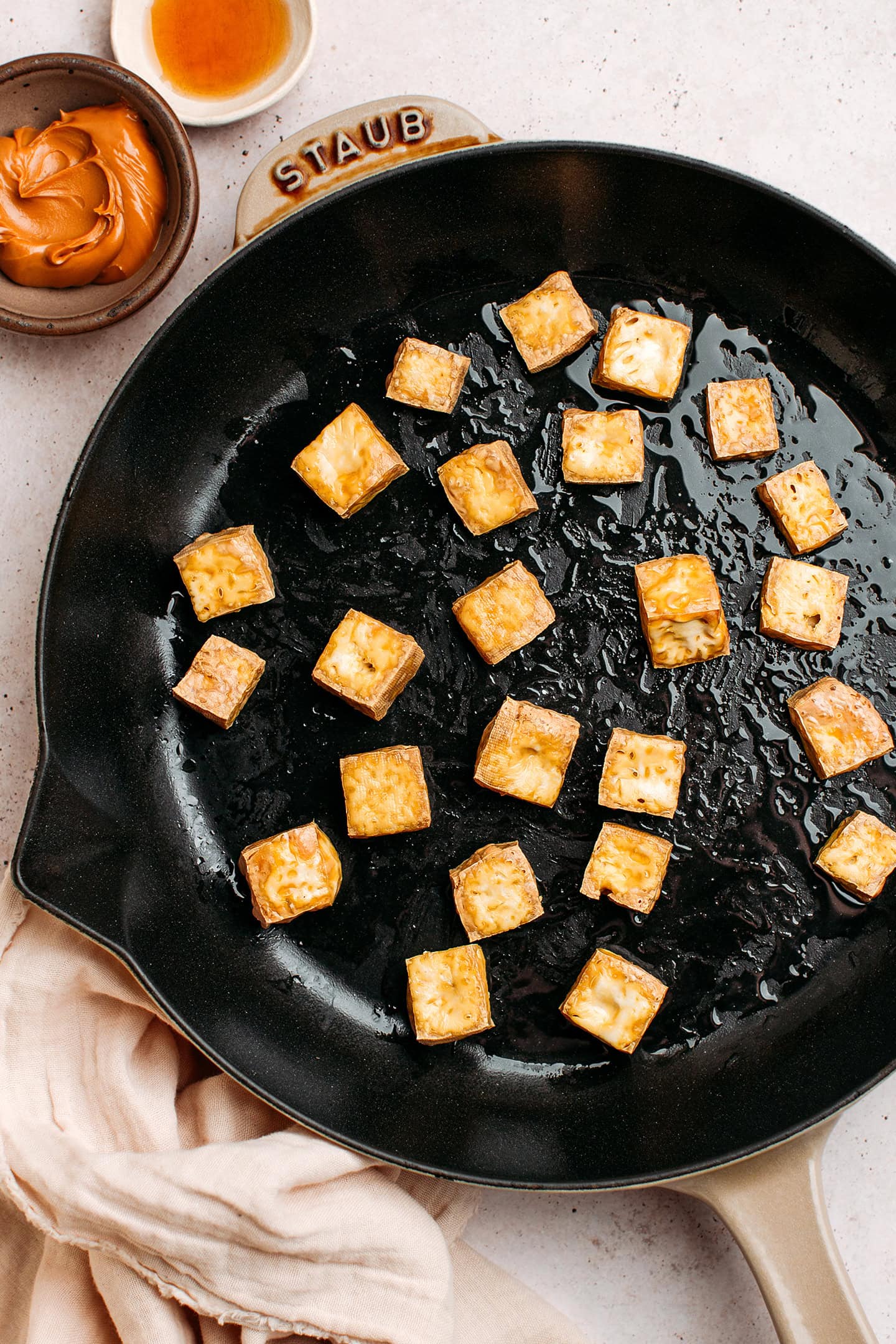 Diced and fried tofu in a pan.