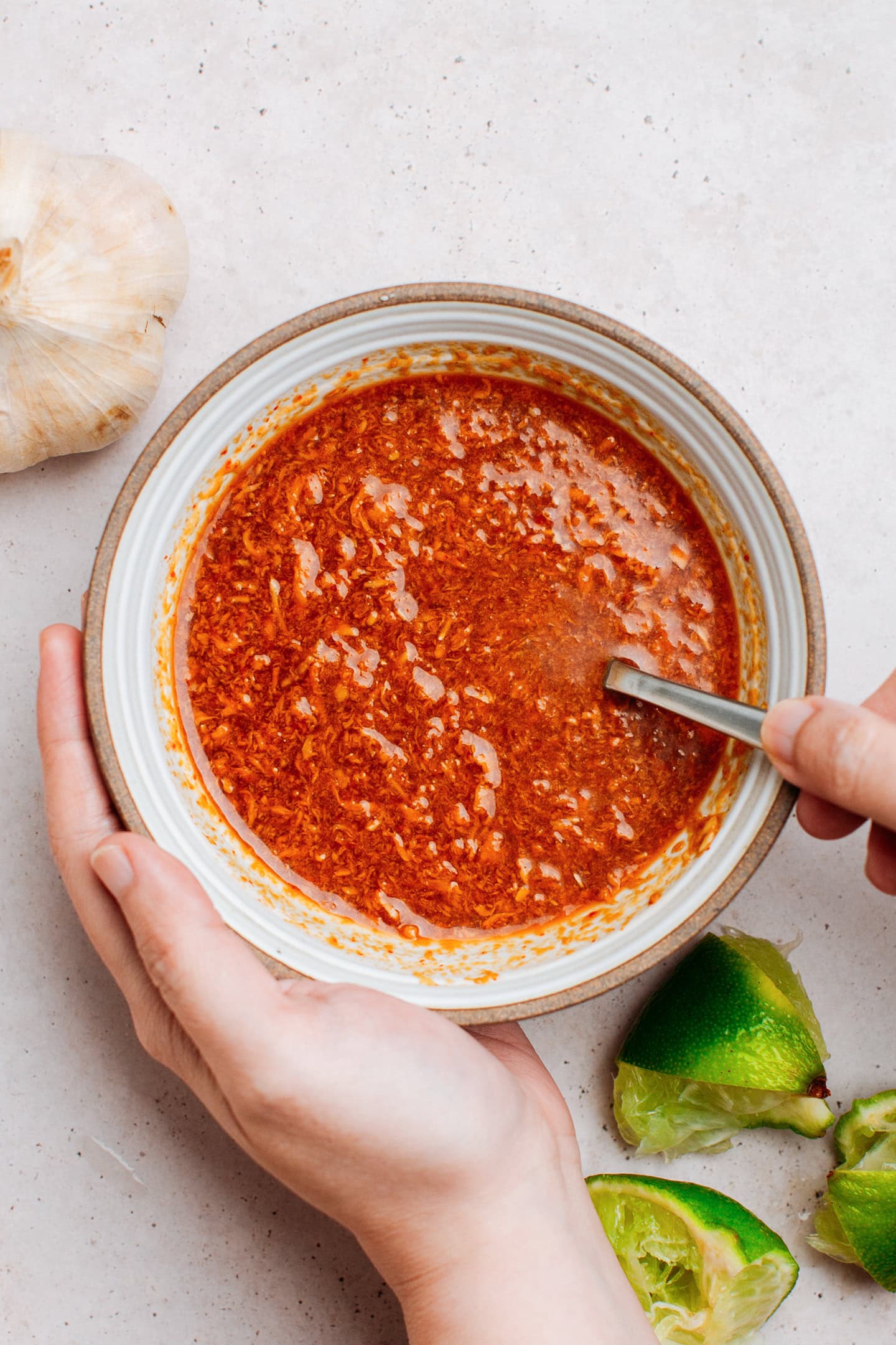 Stirring satay peanut sauce in a small bowl.