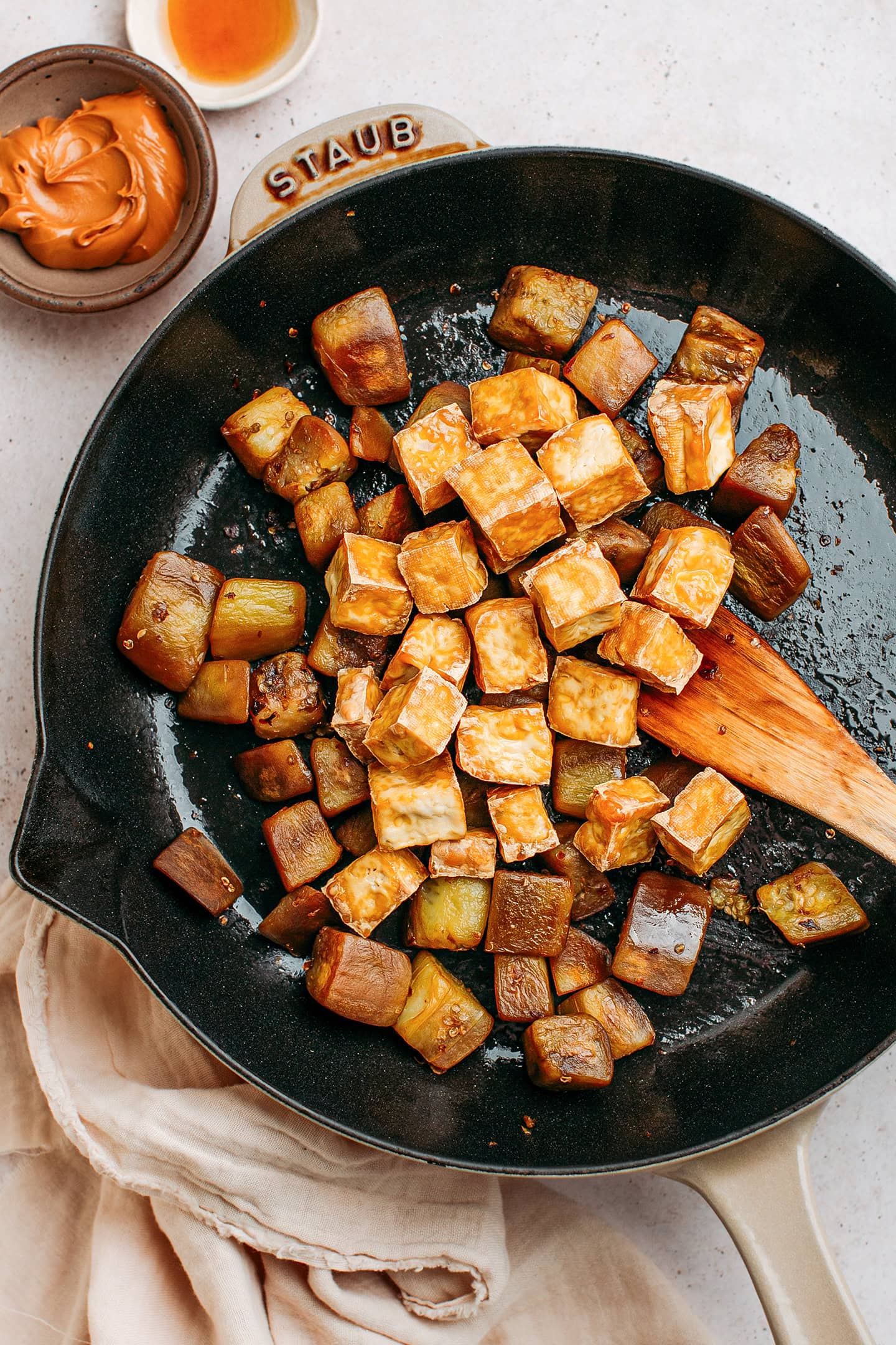 Sautéed eggplant and fried tofu in a skillet.