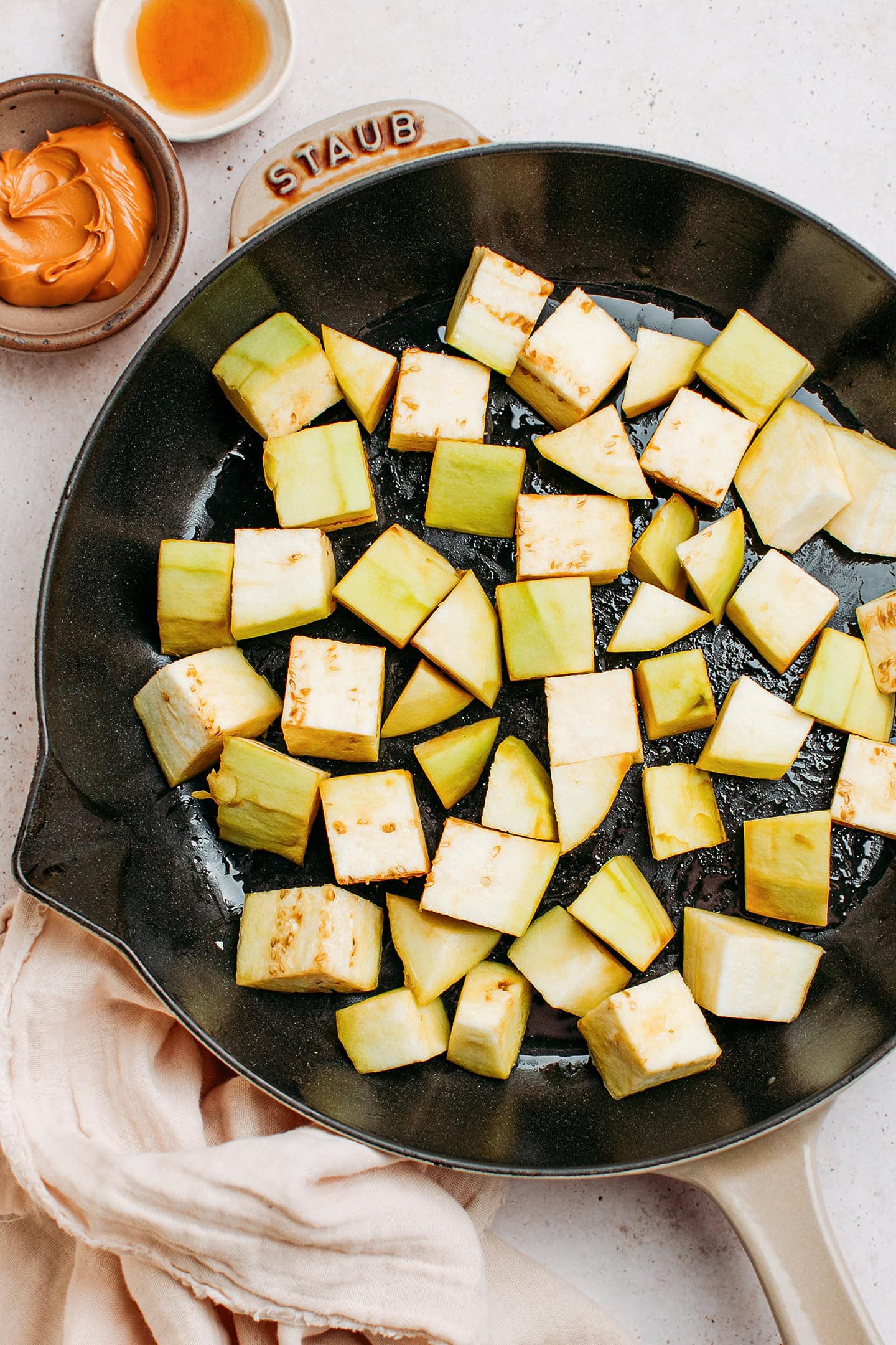 Diced eggplant in a skillet.