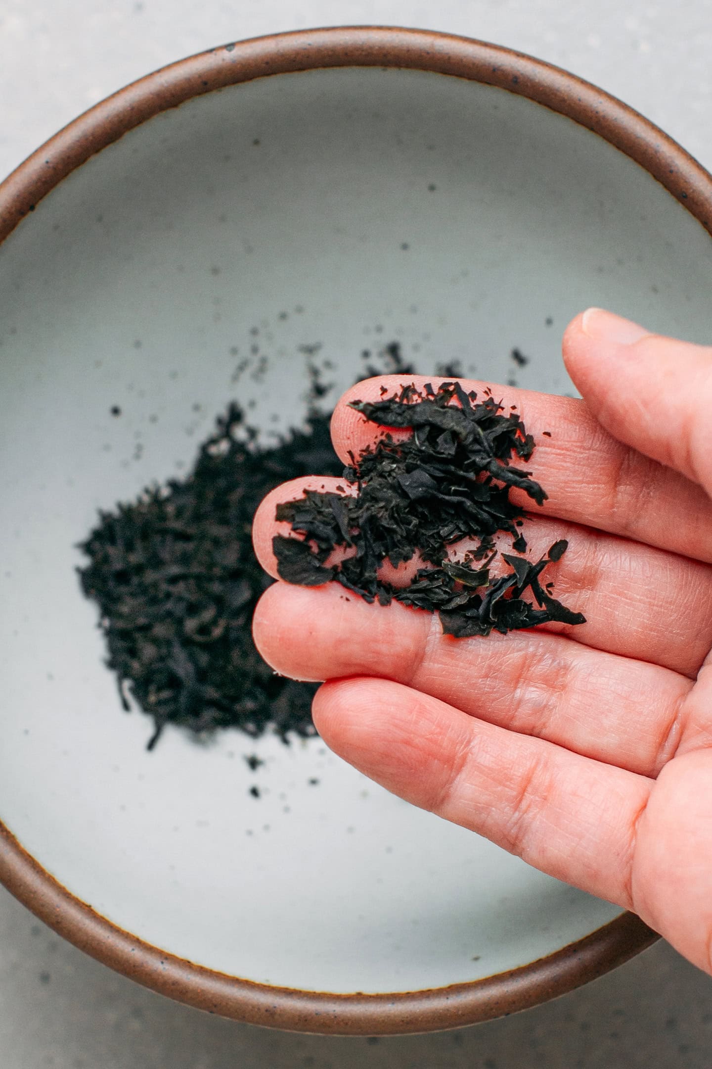 Holding crushed wakame over a bowl.