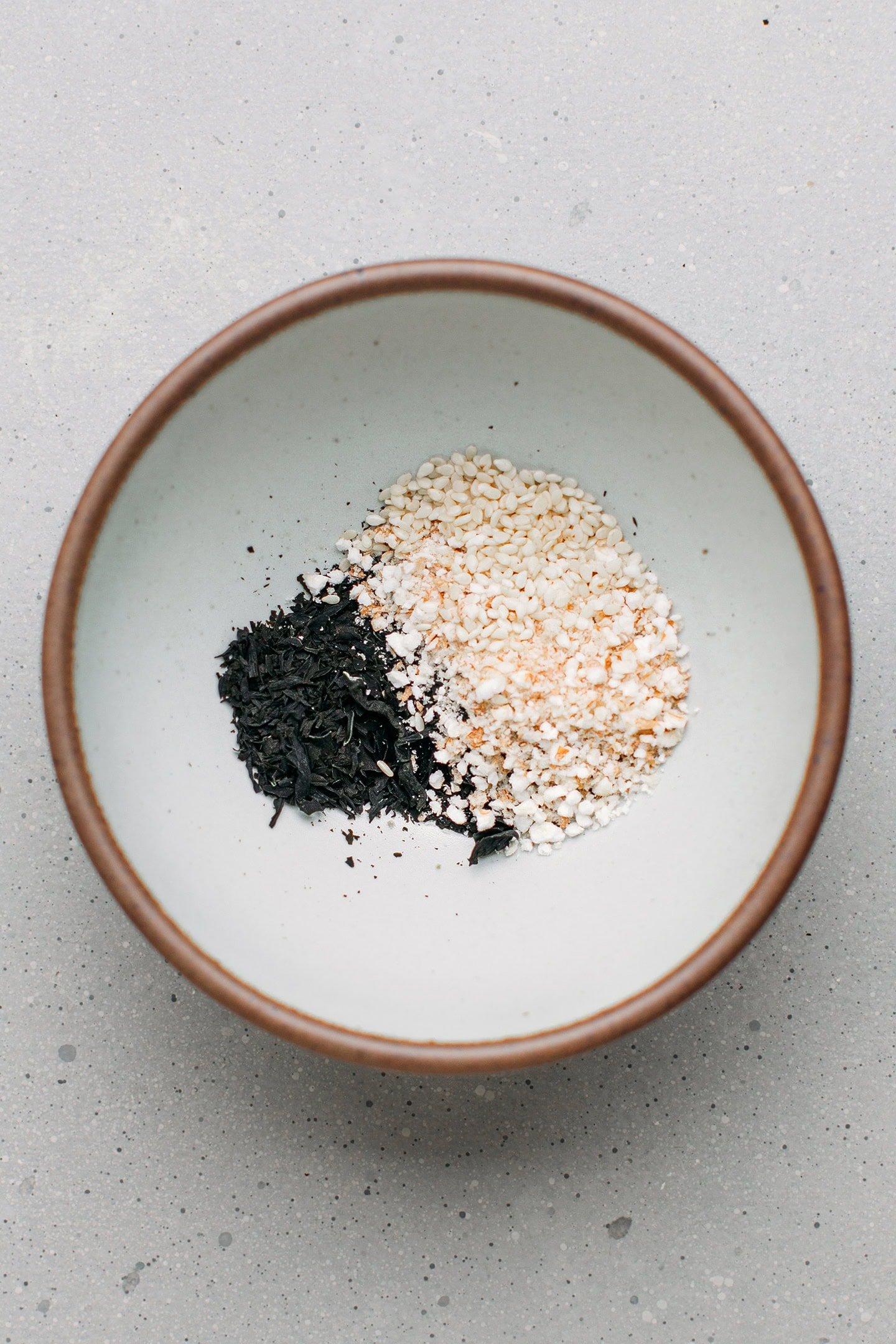 Dried wakame, sesame seeds, and puffed cereals in a bowl.