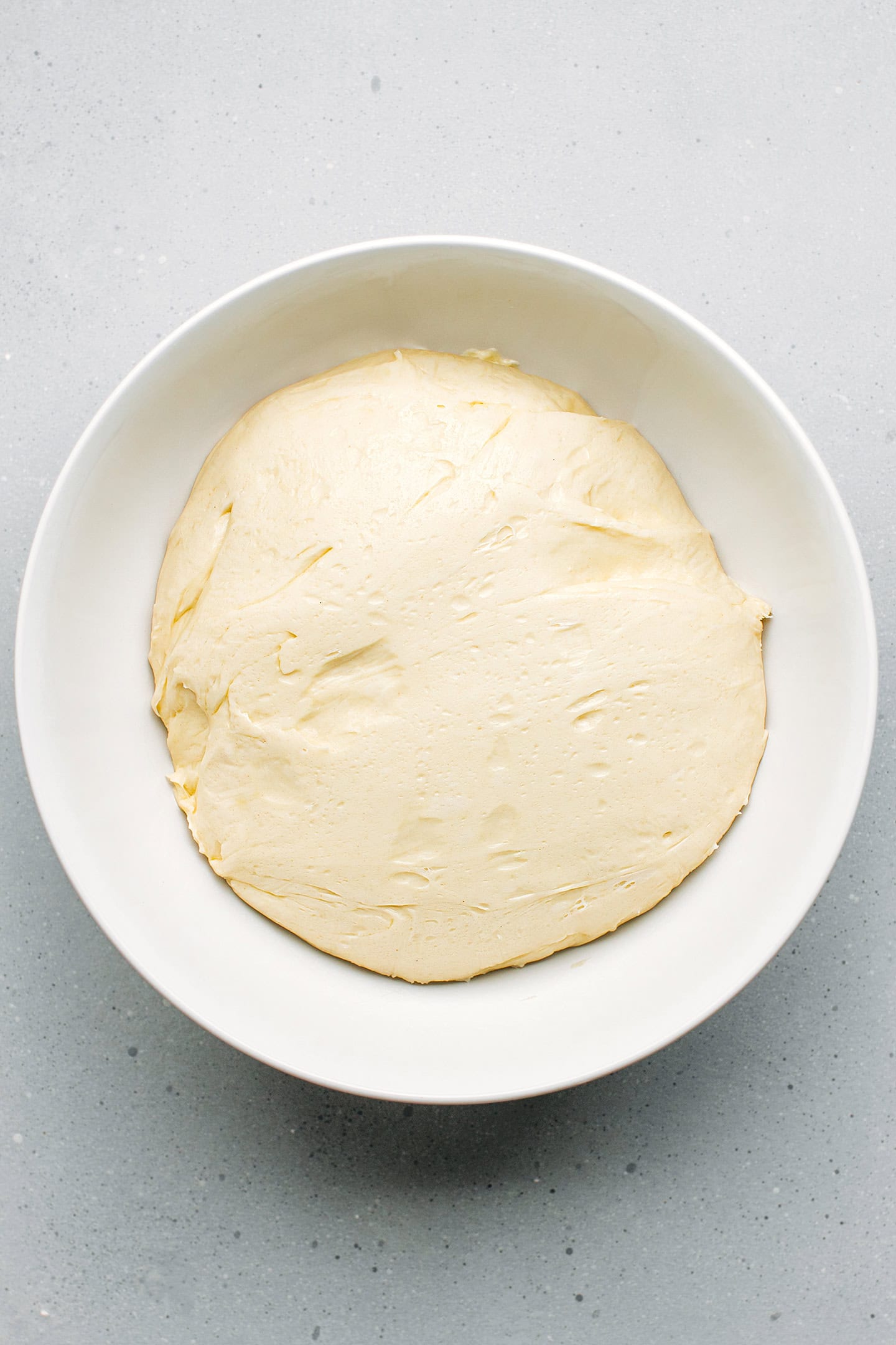 Brioche dough after first rise in a mixing bowl.