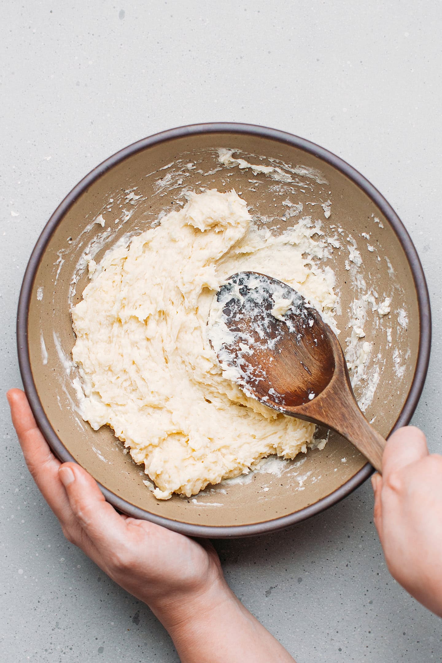 Mixing flour and hot water in a bowl.