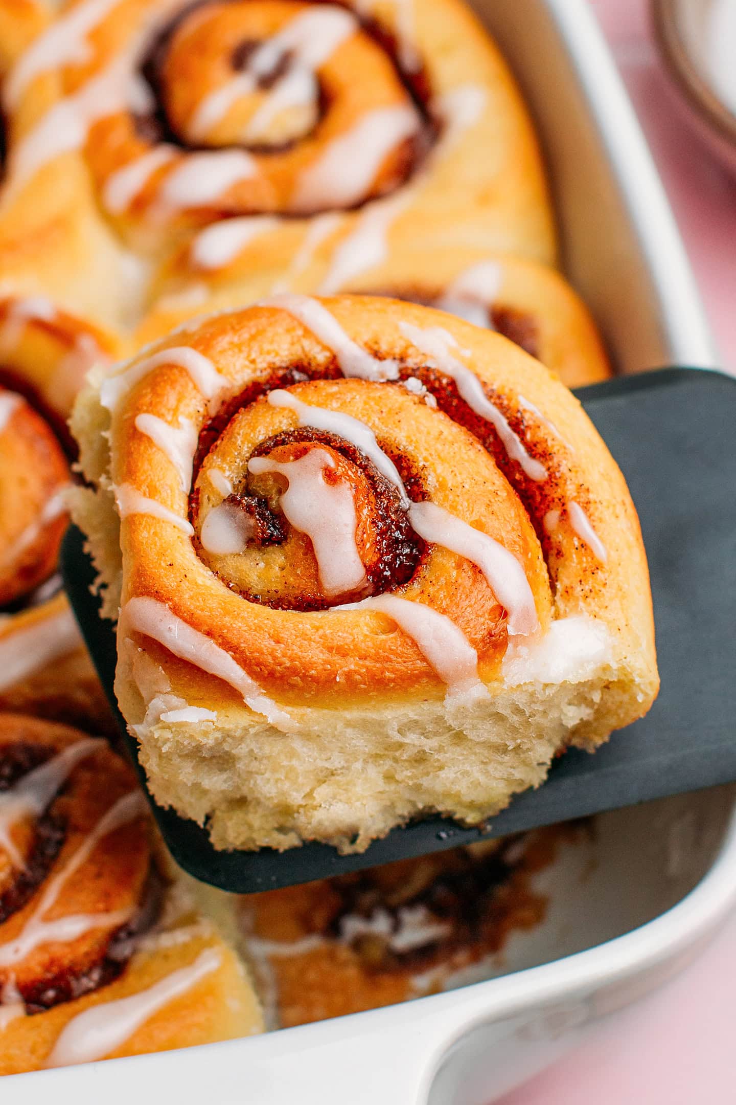 Close-up of a cinnamon rolls glazed with sugar icing.