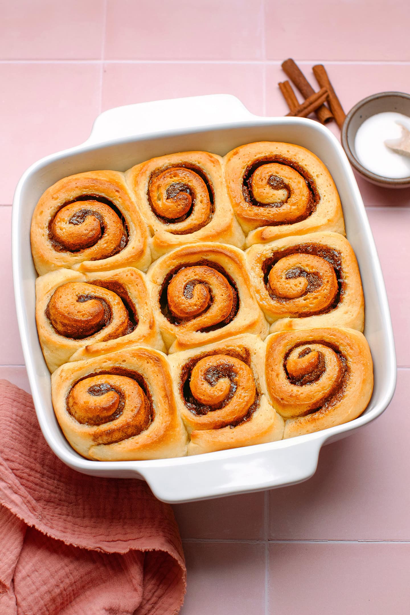 Baked cinnamon rolls in a baking pan.