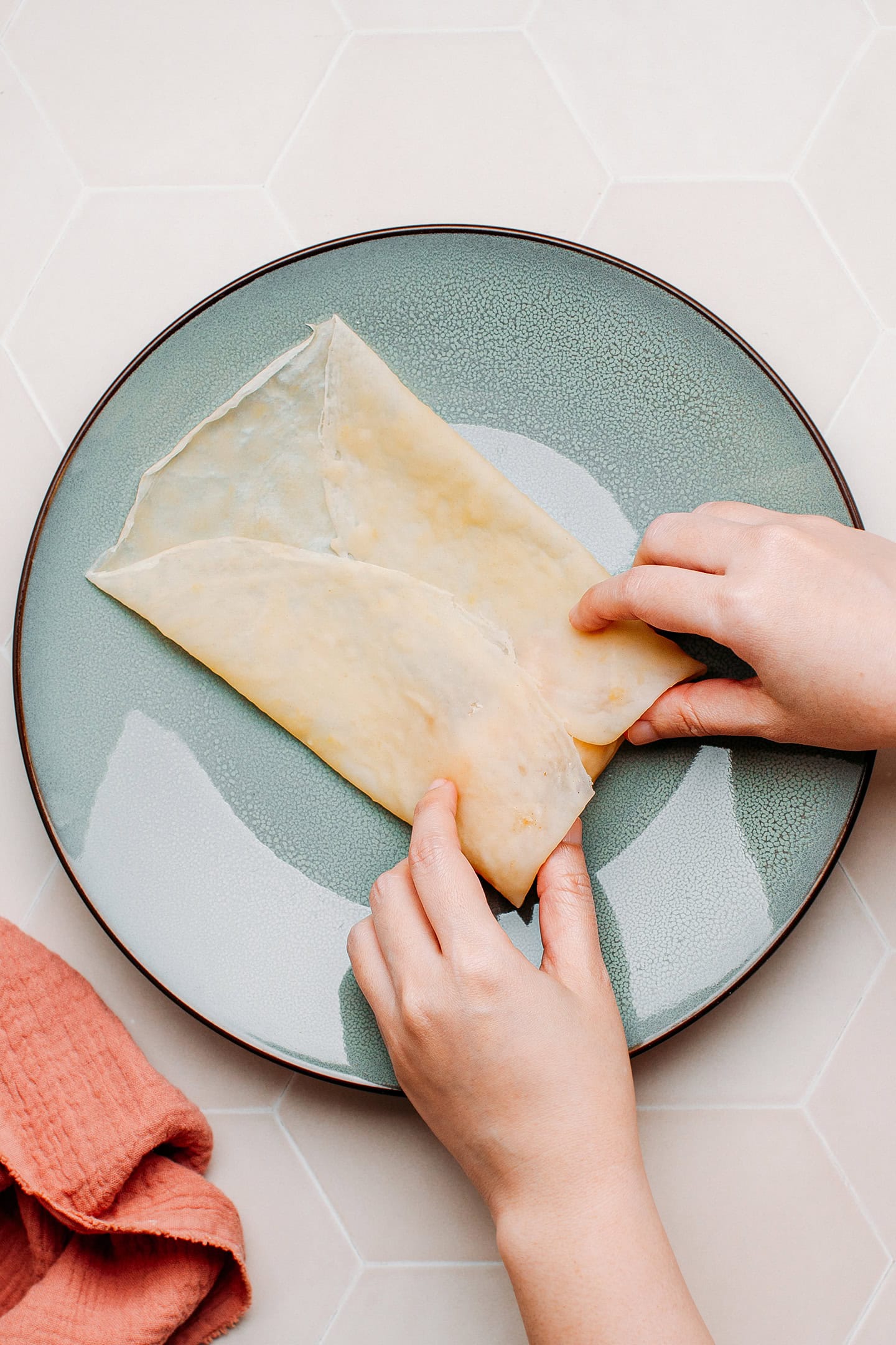 Wrapping sautéed apples with an egg roll wrapper.