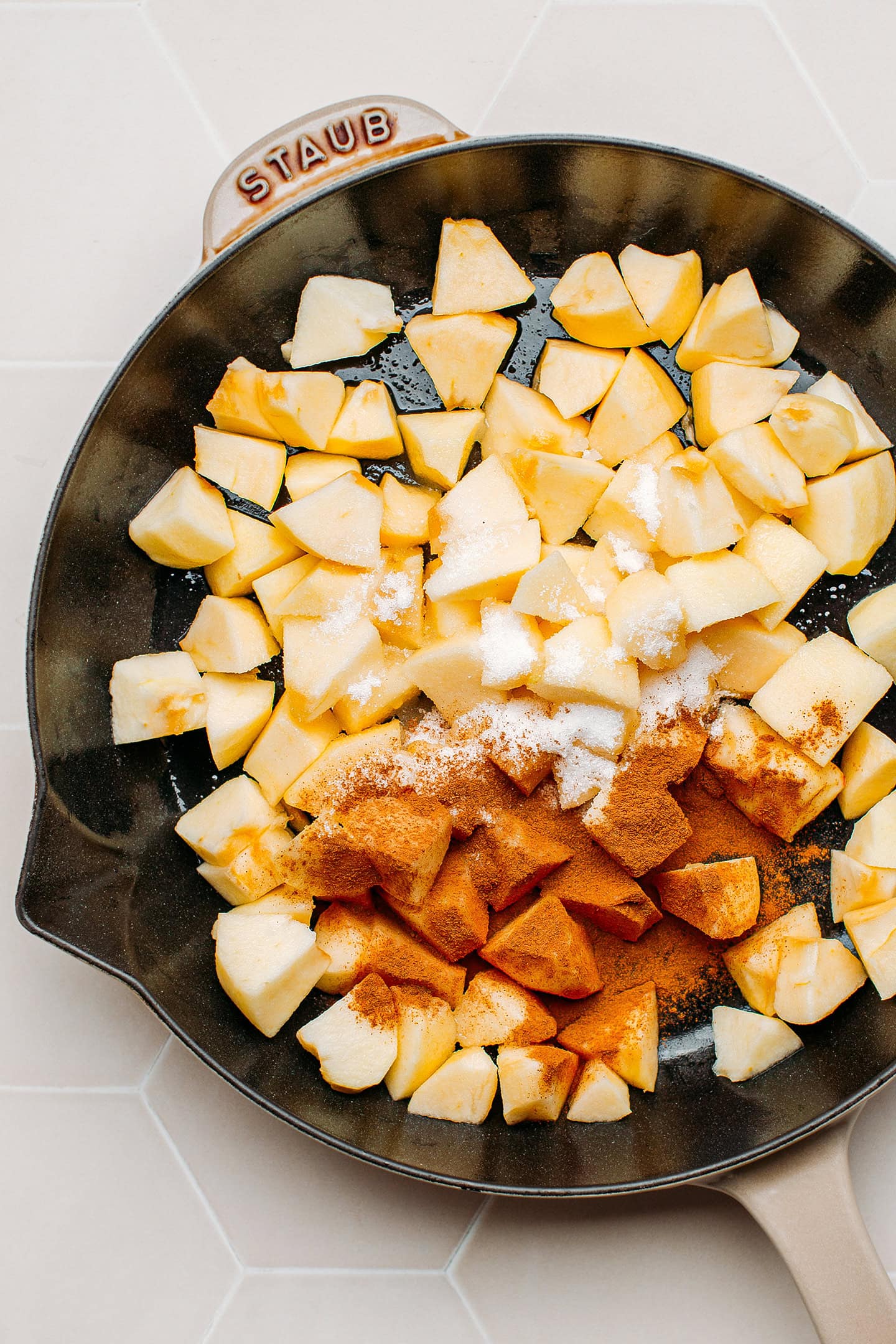 Diced apples, sugar, and cinnamon in a skillet.