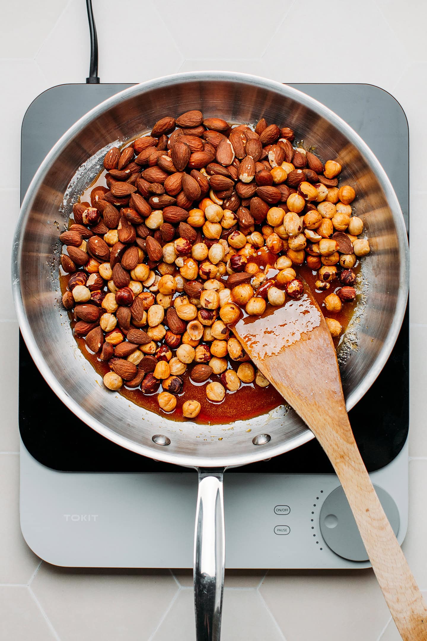 Caramel, hazelnuts, and almonds in a pan.