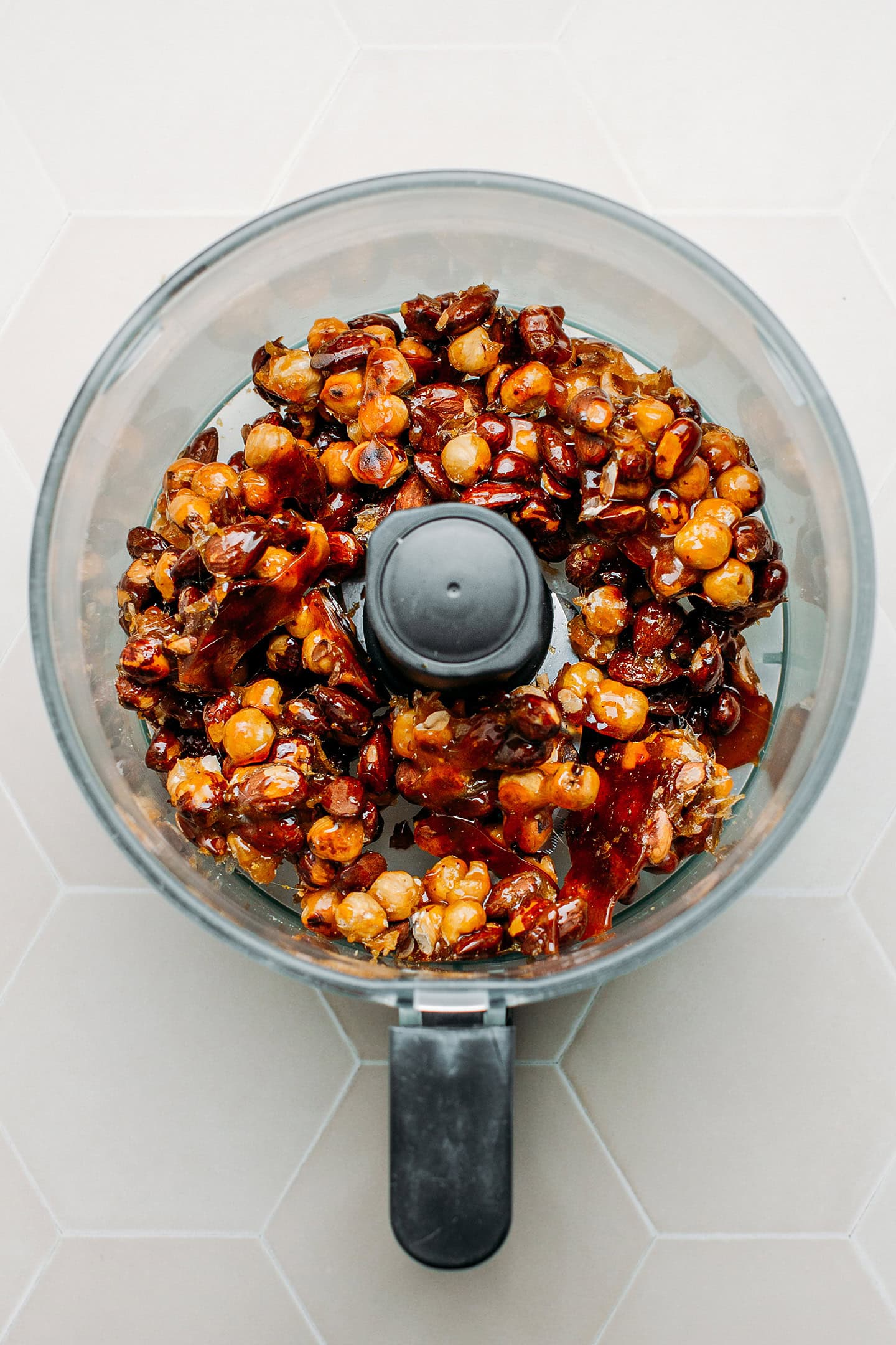 Caramelized hazelnuts and almonds in a food processor.