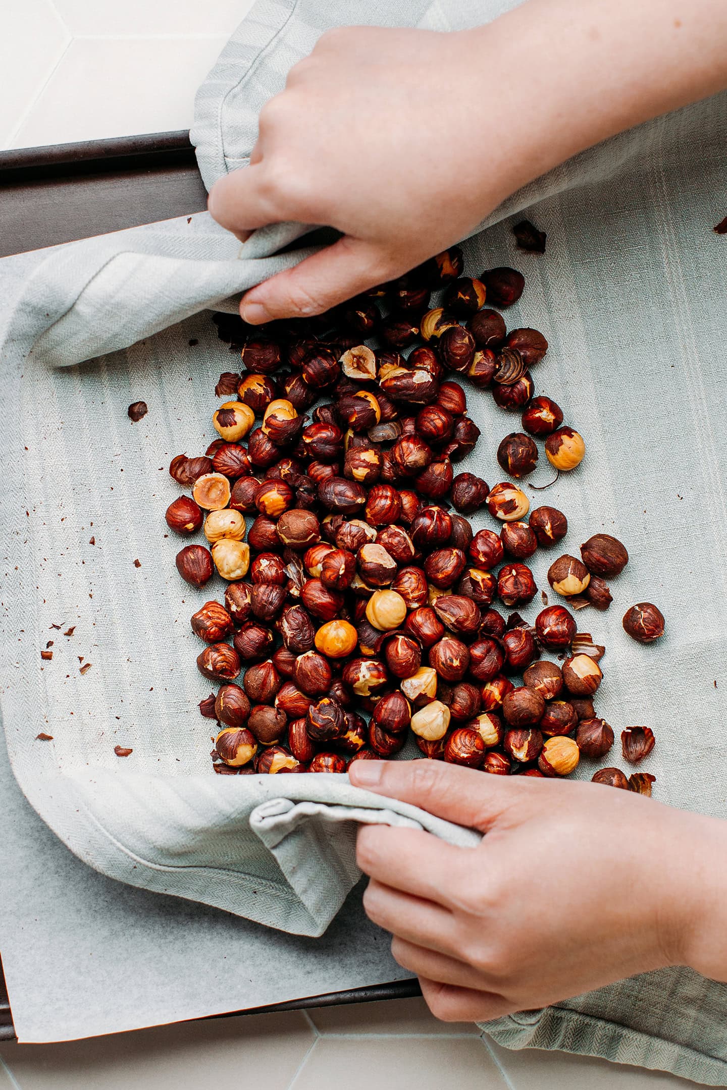 Roasted hazelnuts on a kitchen towel.