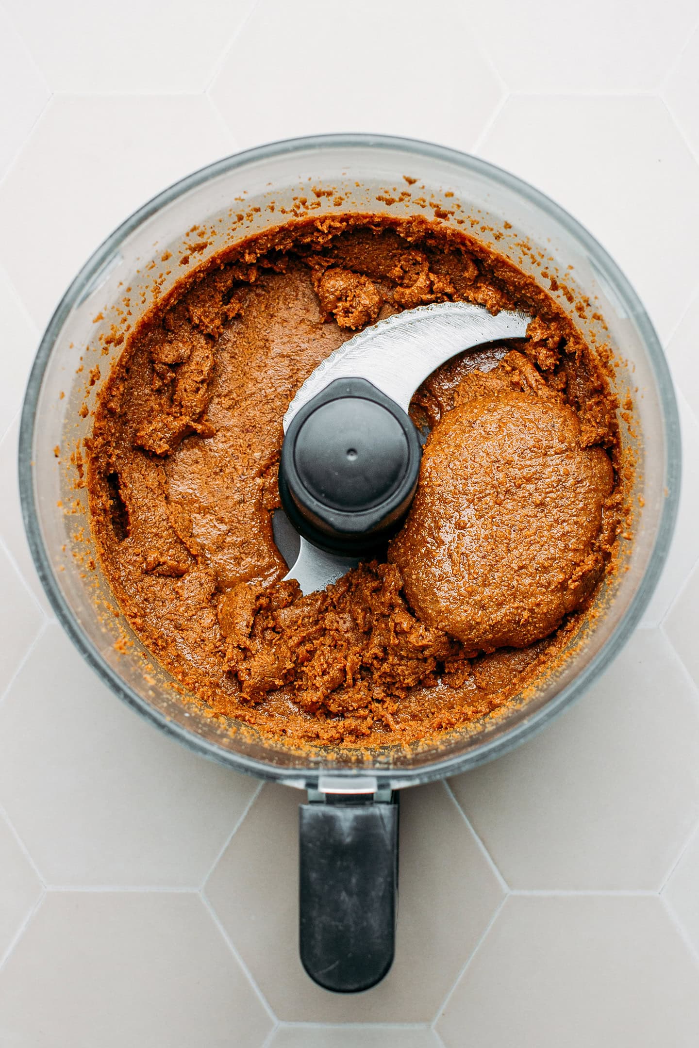 Caramelized hazelnut and almond paste in a food processor.