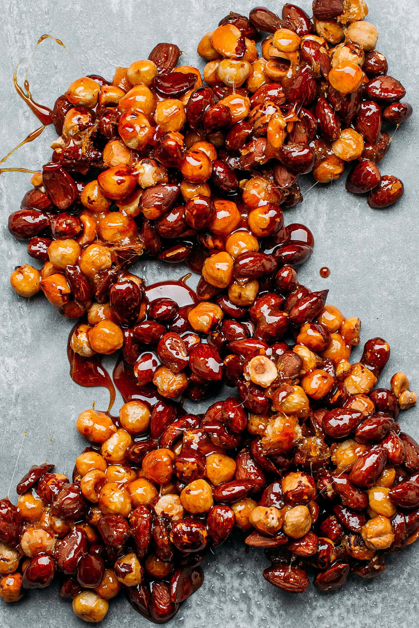 Caramelized hazelnuts and almonds on a baking sheet.