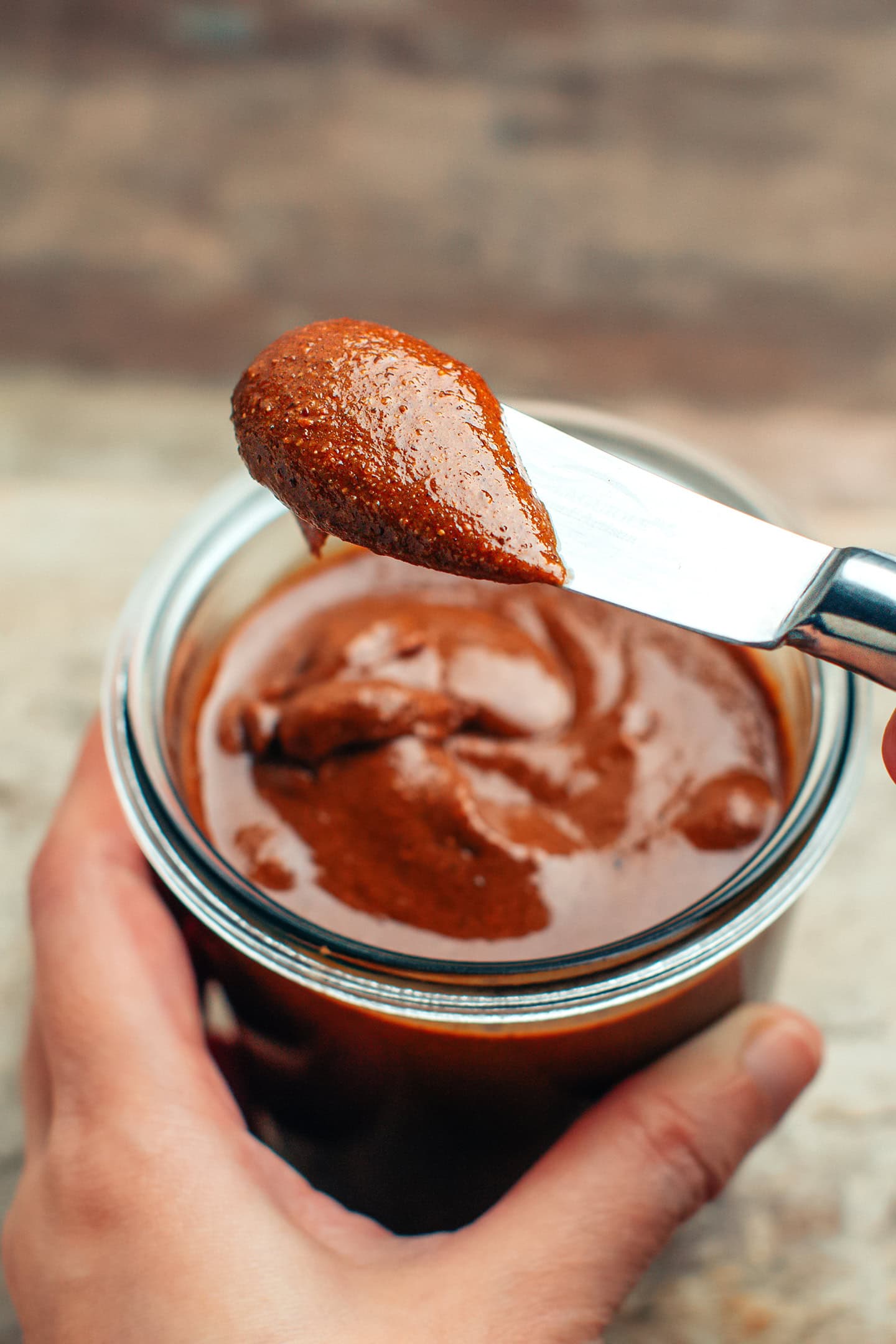 Close-up of a butter knife dipped into chocolate spread.