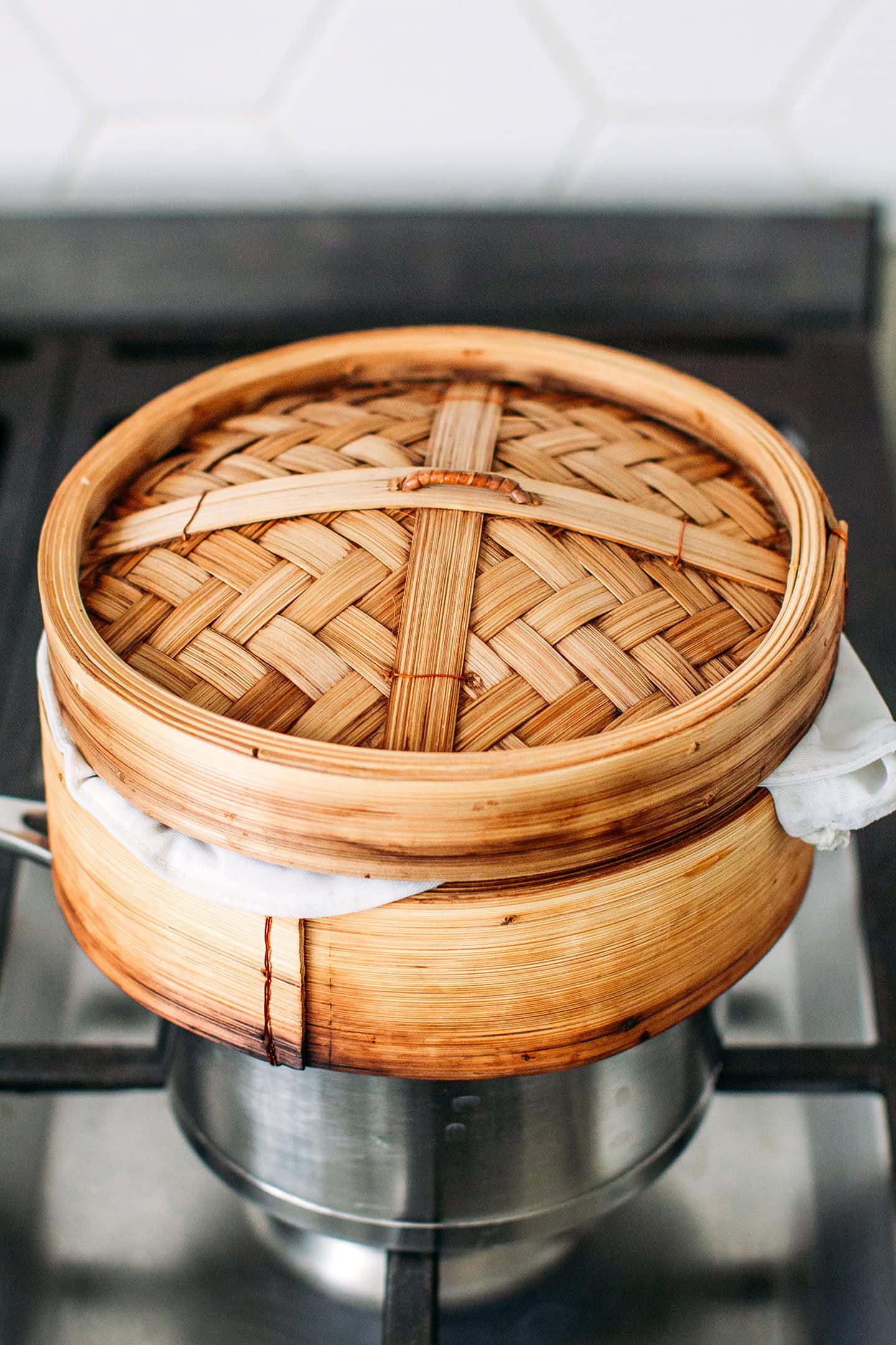 Bamboo basket sitting on a pot of boiling water.