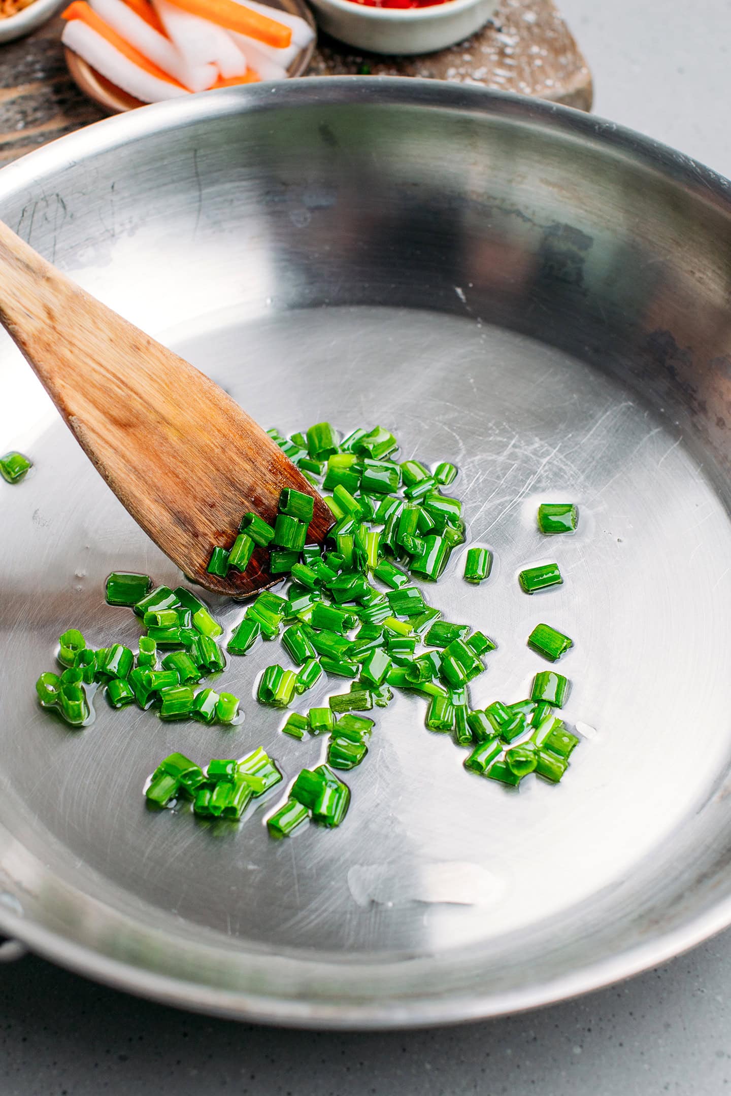 Sautéed chopped green onions in a pan.