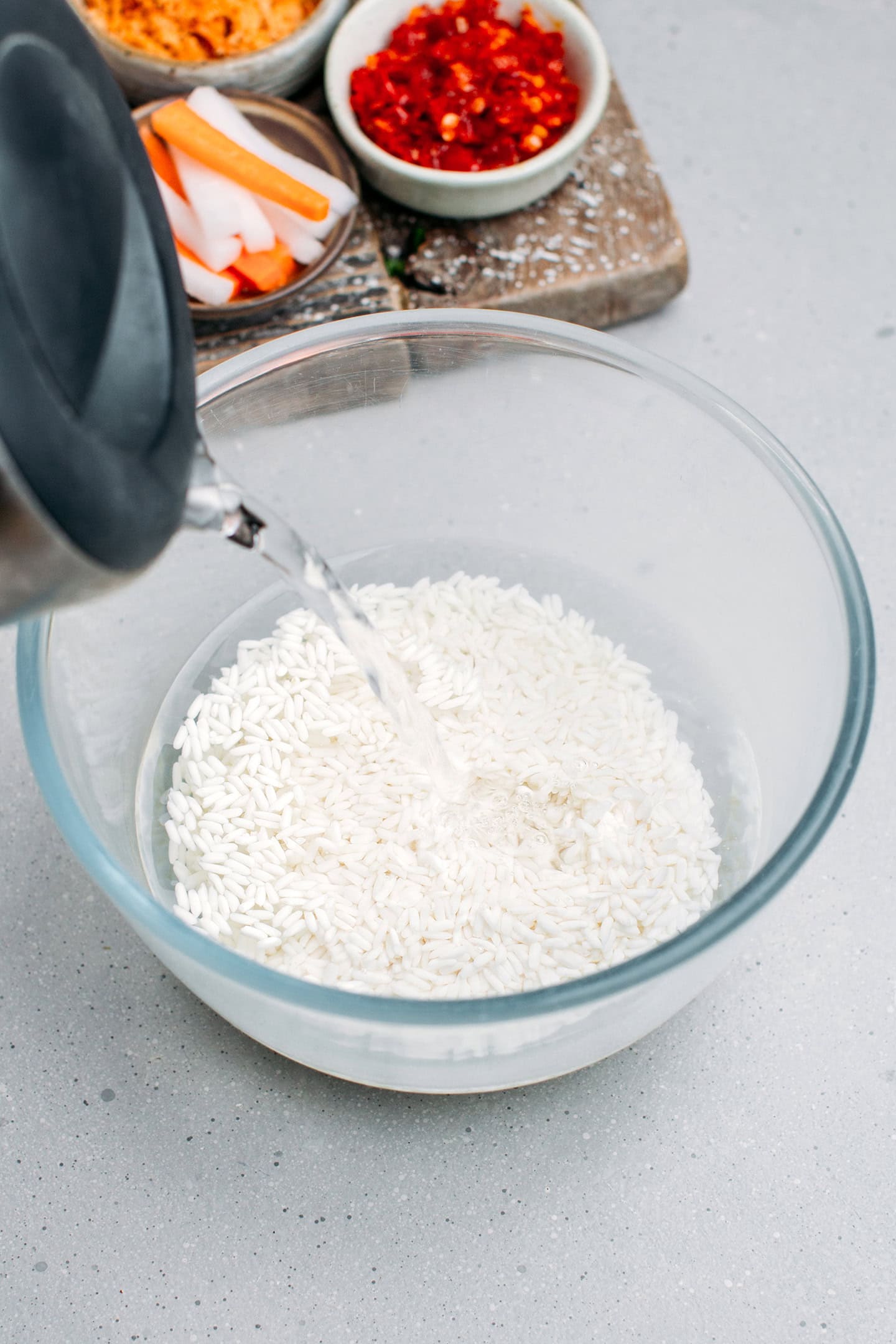 Pouring water into a bowl containing sticky rice.