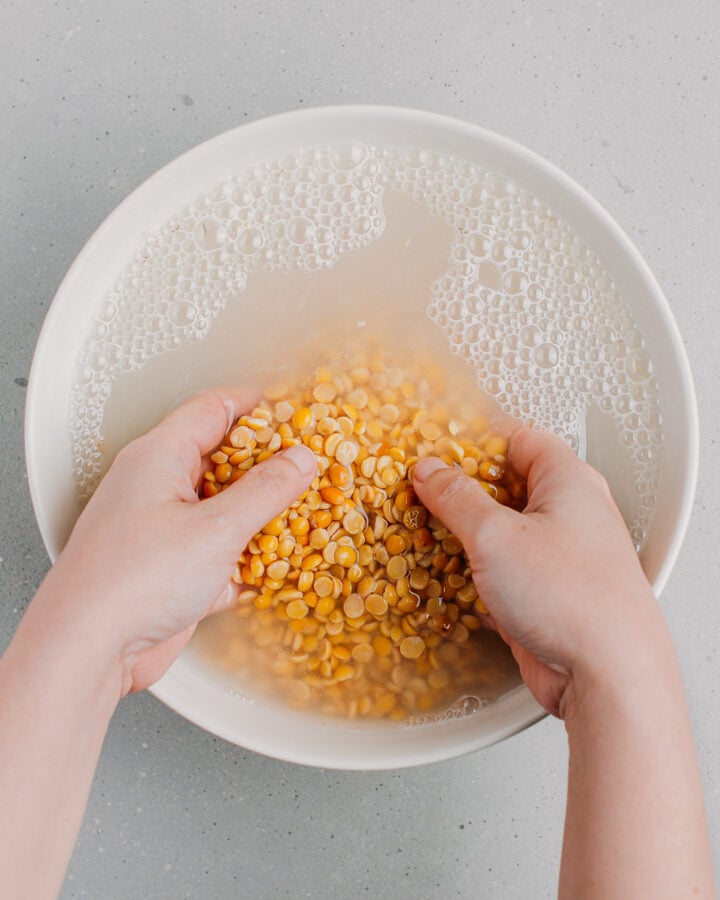 Rinsing soybeans in a bowl of water.