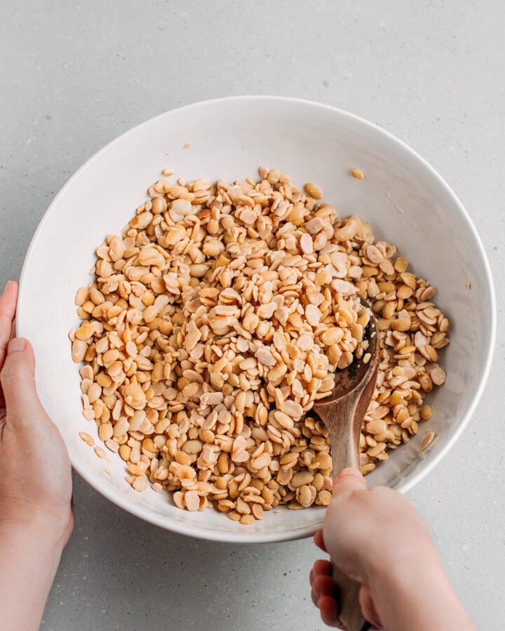 Tossing cooked soybeans with white vinegar.