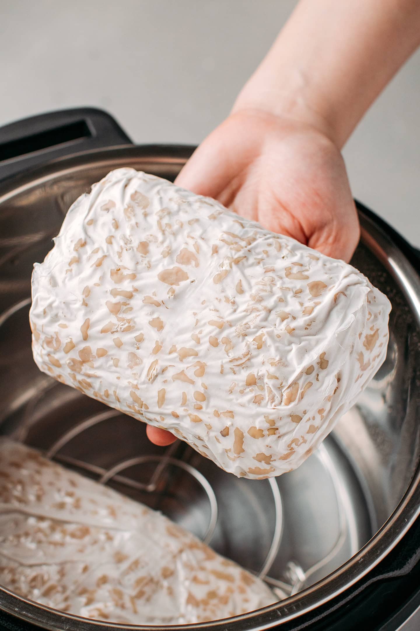 Holding a loaf of homemade tempeh.