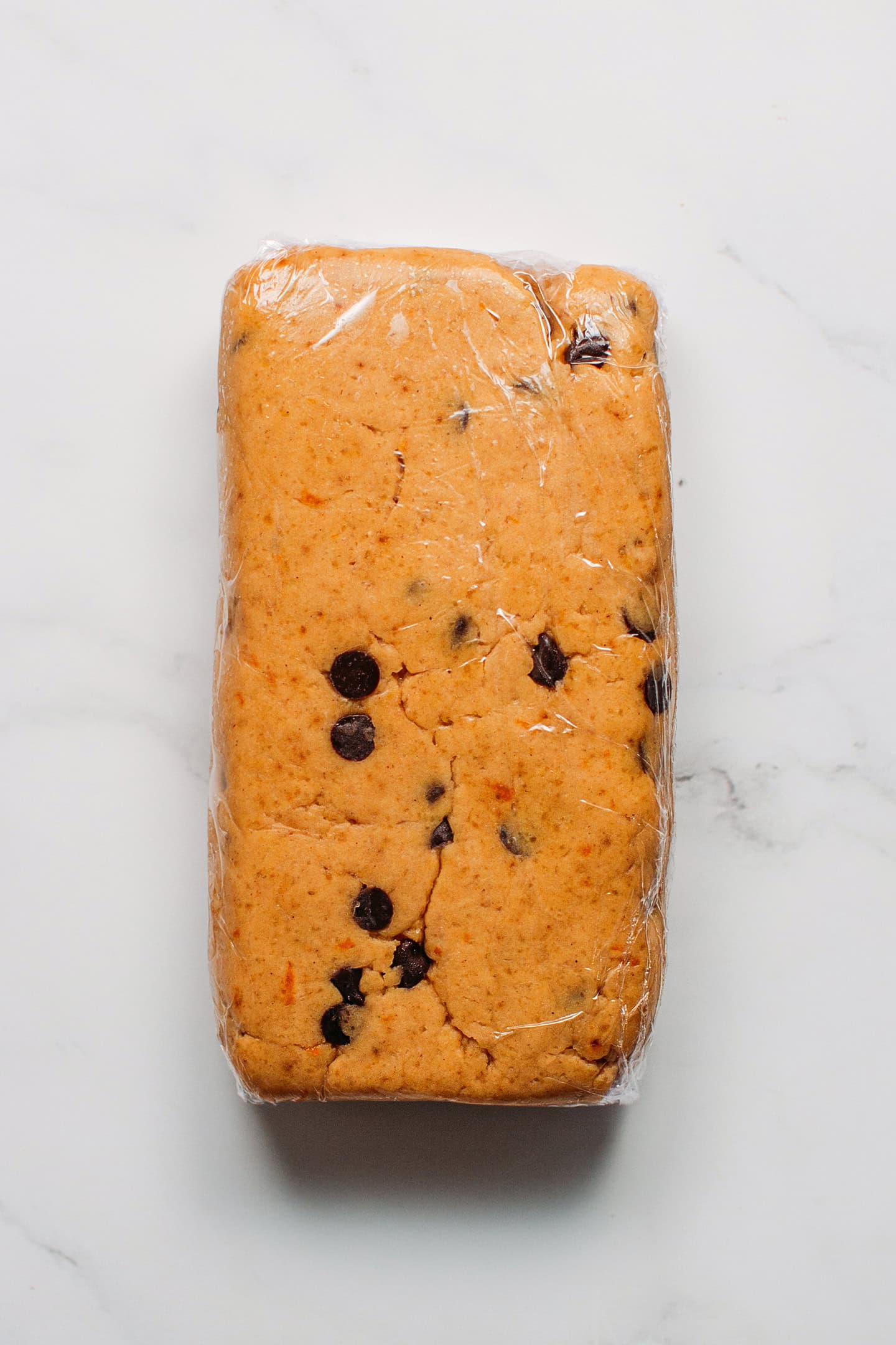 Block of shortbread cookie dough wrapped in a plastic wrap.