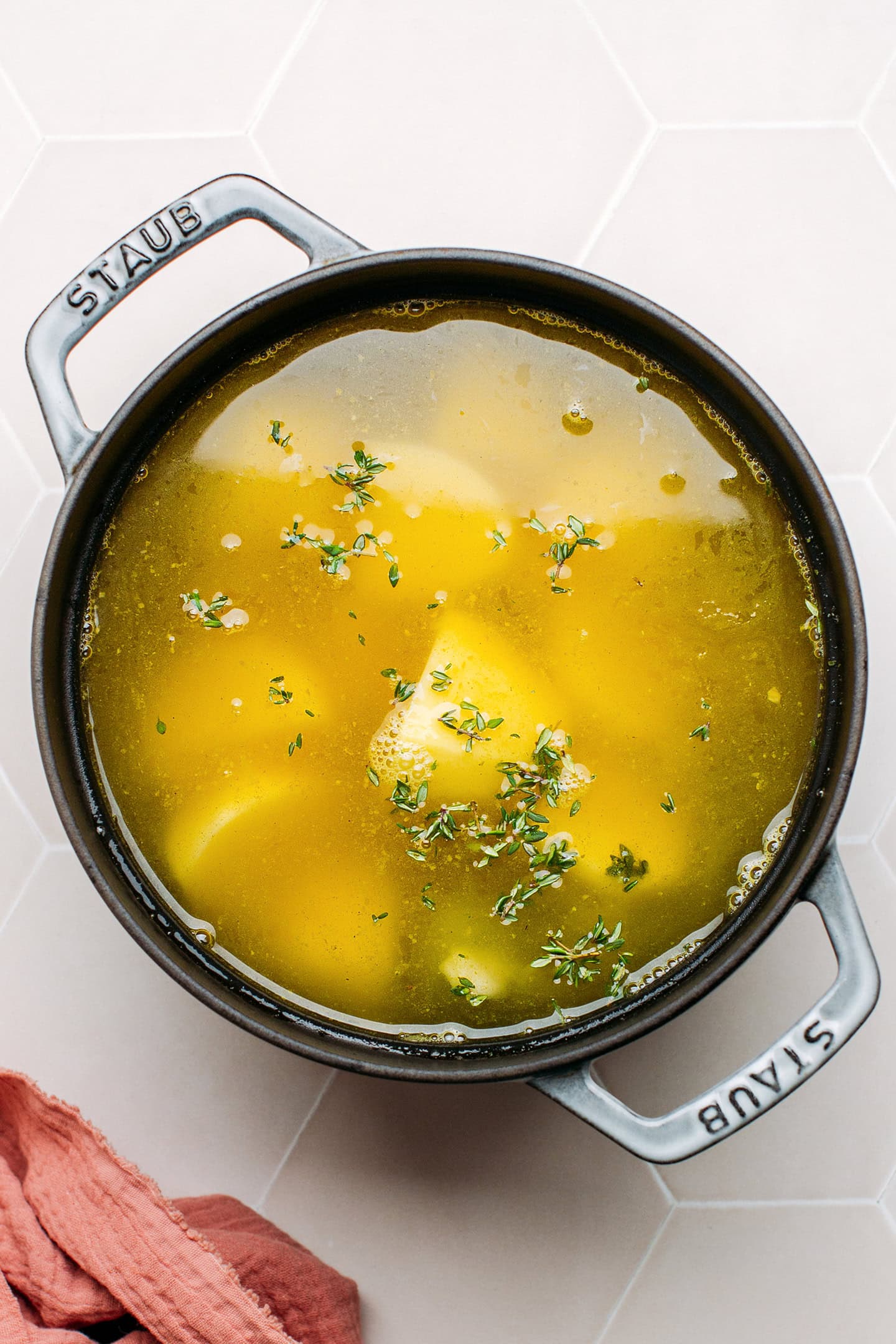 Potatoes, leeks, and vegetable broth in a pot.