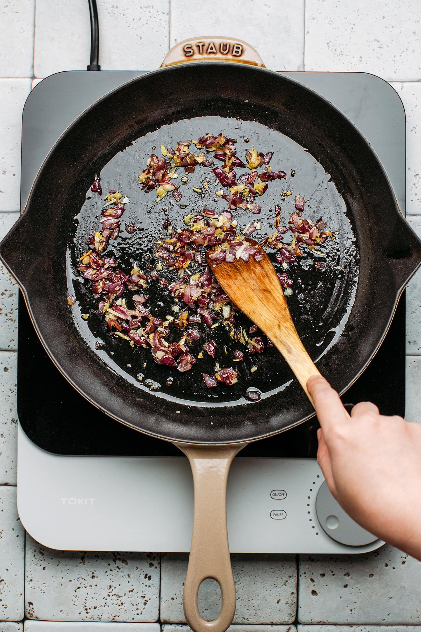 Sautéed onion, ginger, and garlic in a pan.