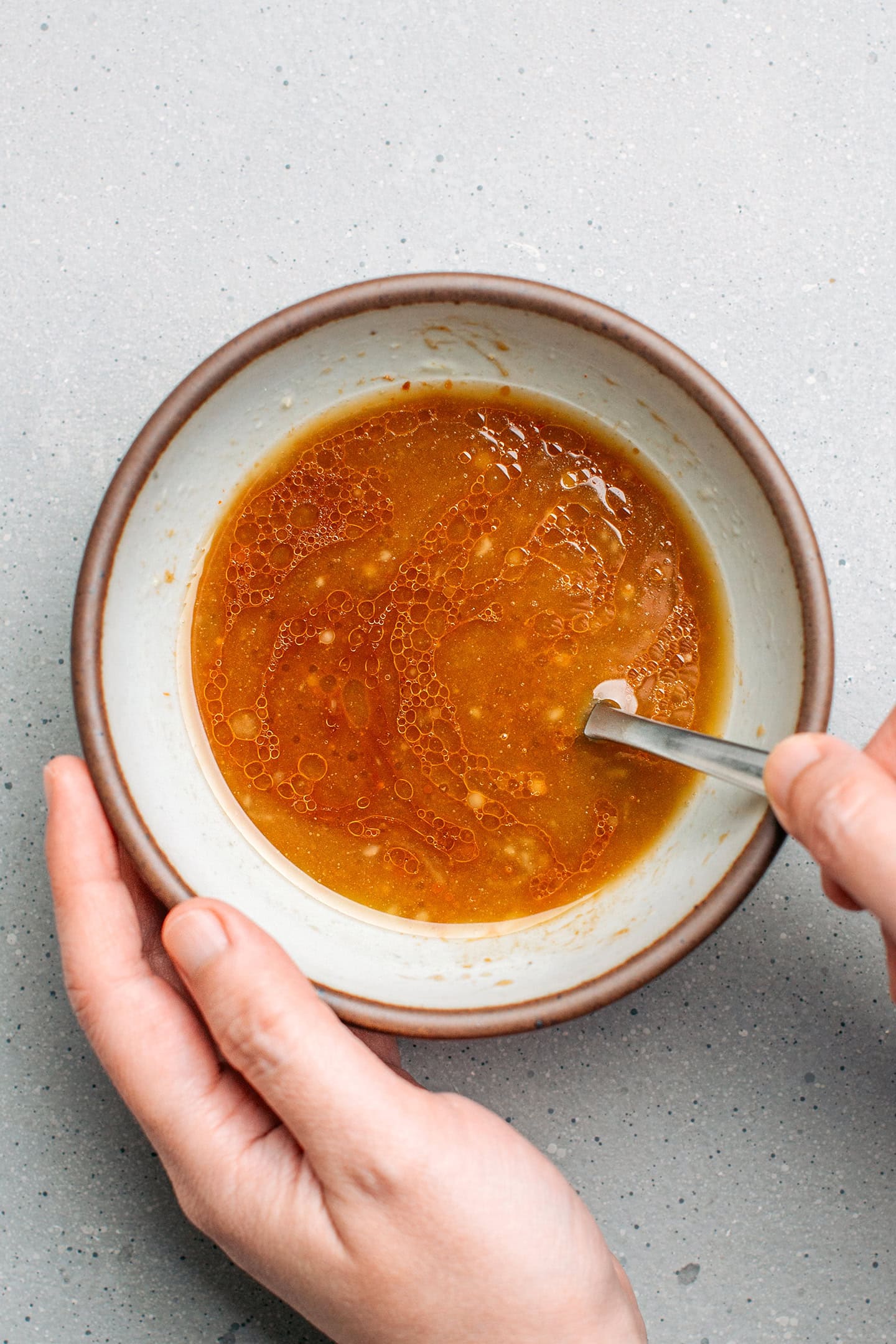 Whisking doenjang sauce in a small bowl.