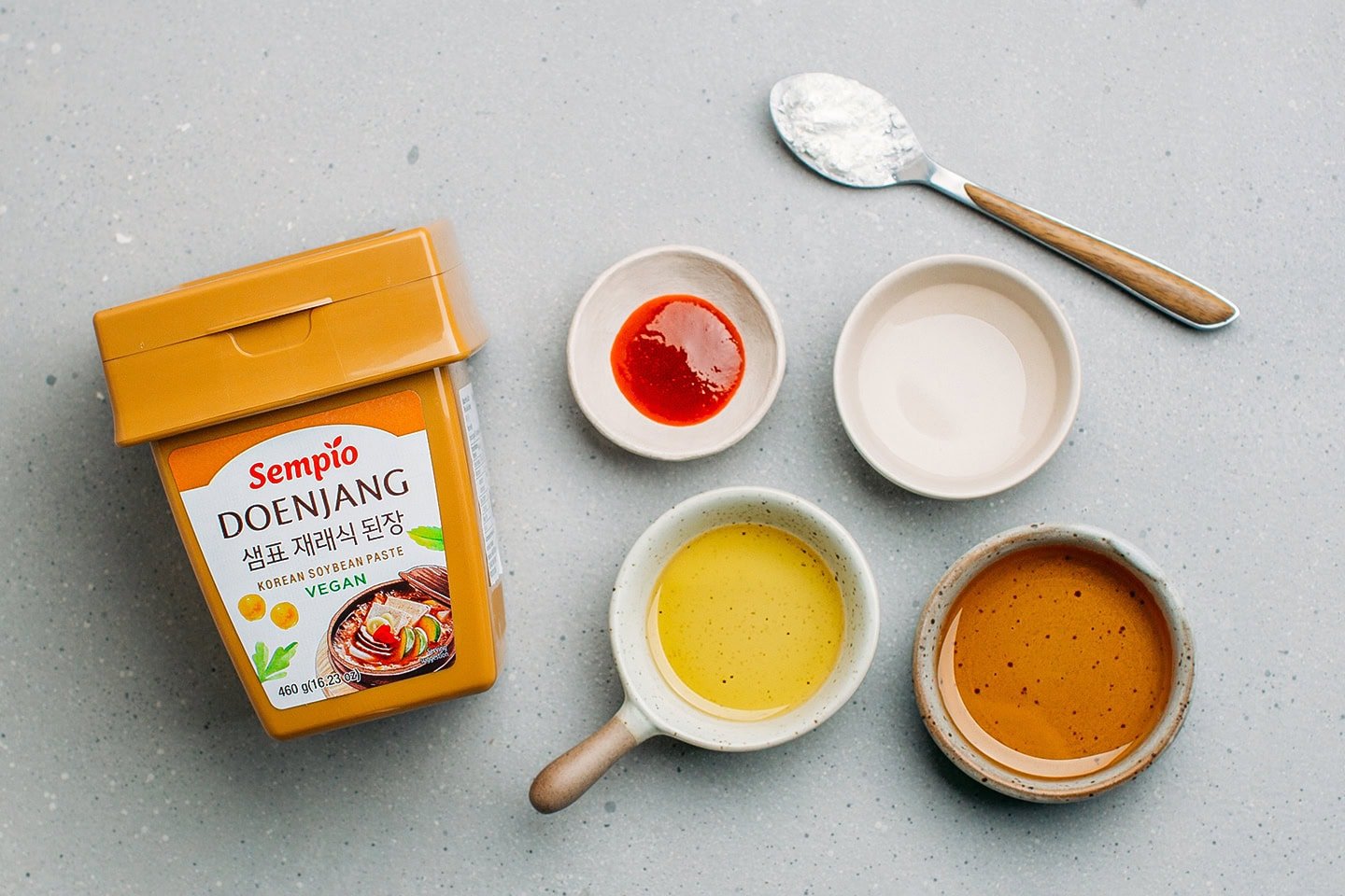 Ingredients like Doenjang paste, sesame oil, maple syrup, and sriracha.