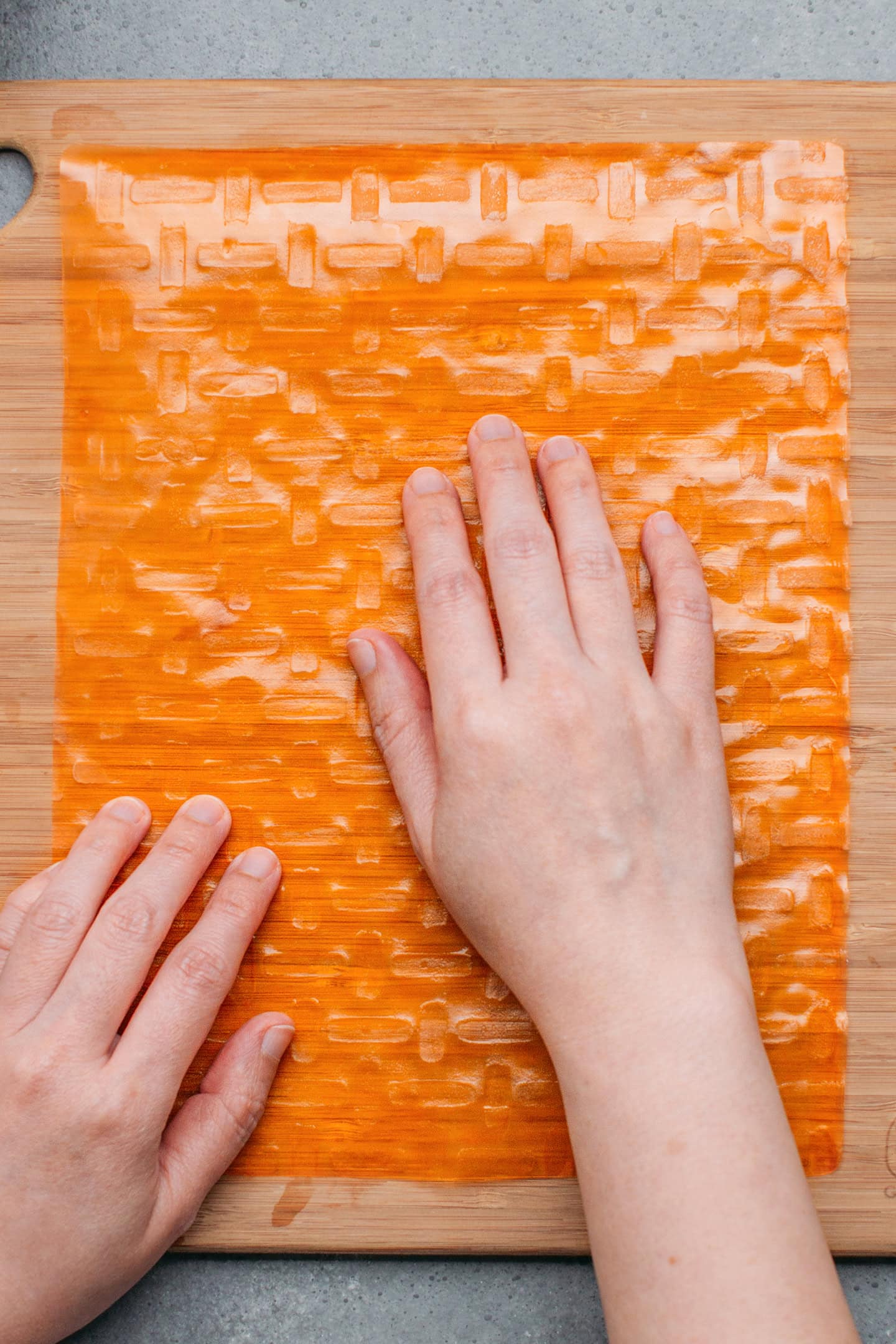 Using hands to wet a sheet of rice paper.