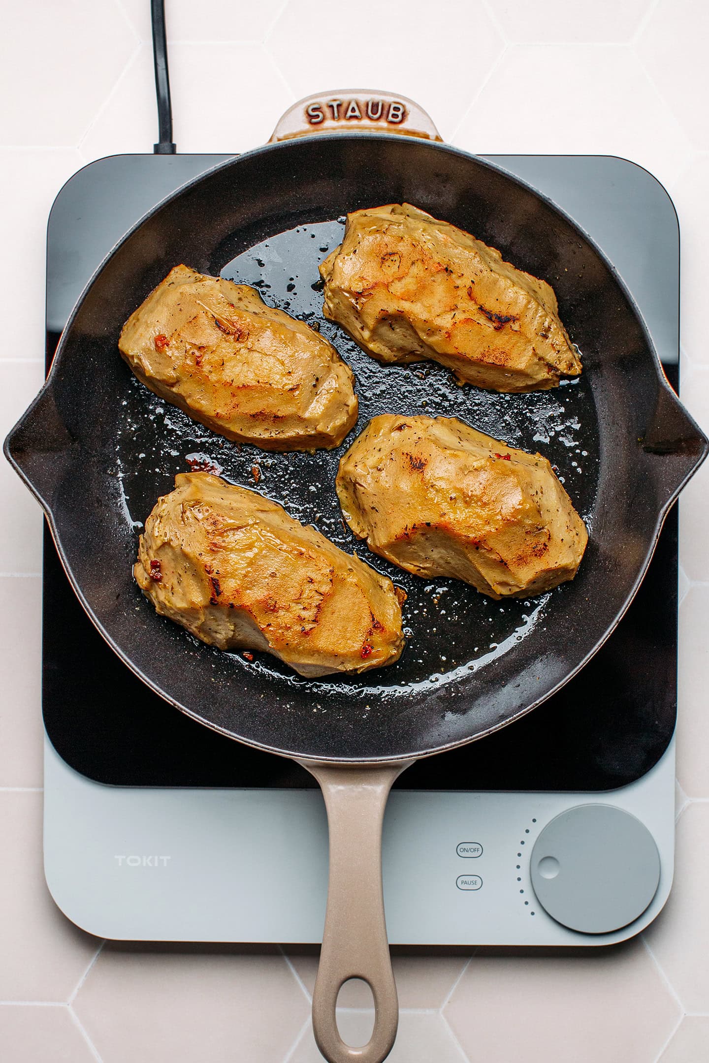 Vegan chicken cutlets in a skillet.