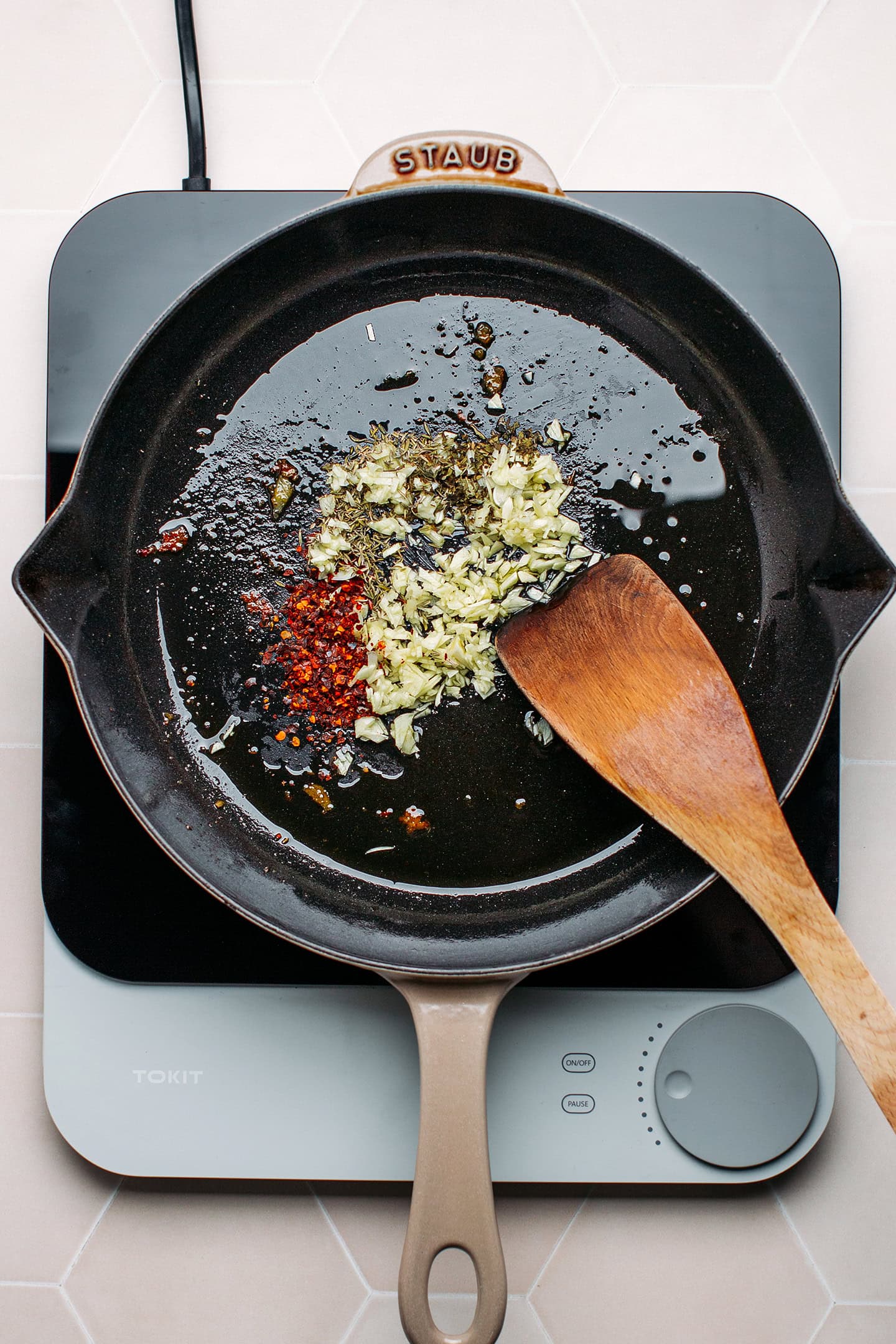 Garlic, dried herbs, and red pepper flakes in a skillet.